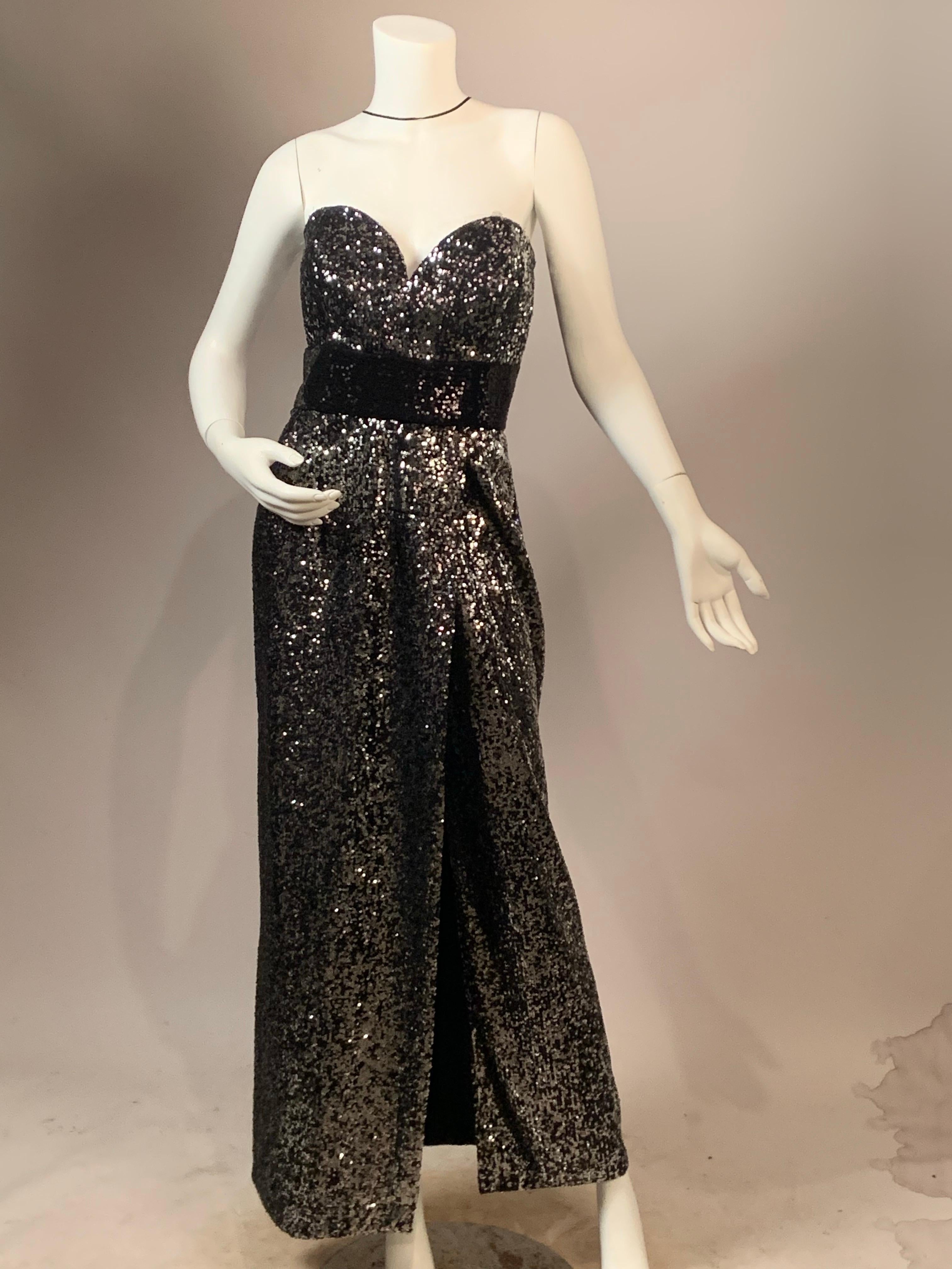 Vicky Tiel, un'americana a Parigi, disegnava abiti da sera molto glamour e questo vestito ne è un esempio meraviglioso. L'abito è ricoperto di piccolissime paillettes argentate sul corpetto e sulla gonna.
Anche l'ampia fascia nera in vita è
