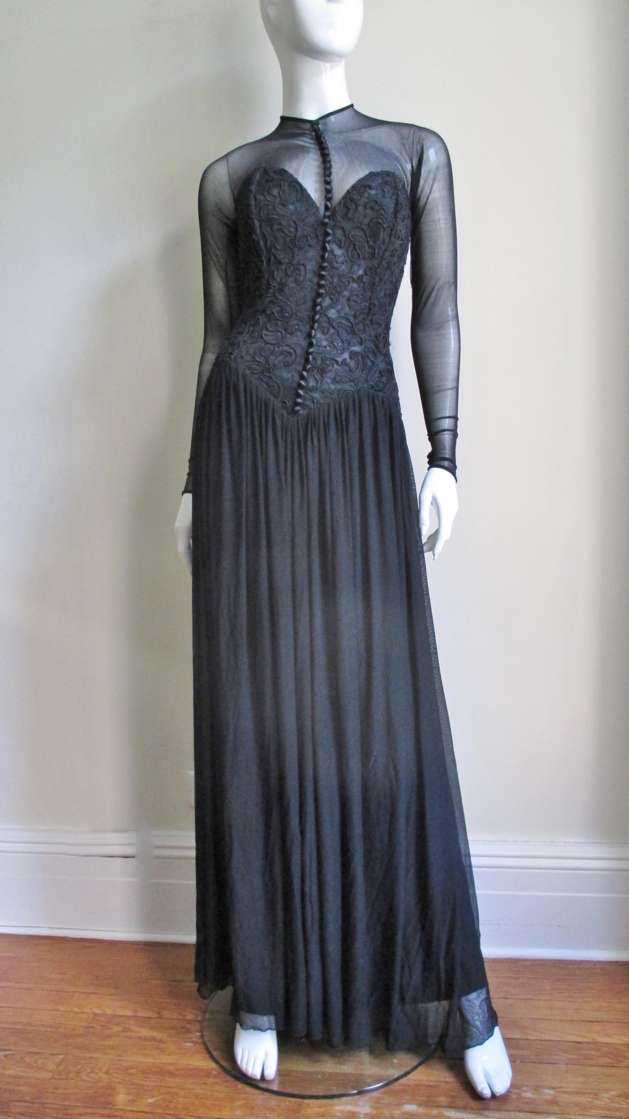 A fabulous black dress gown from Vicky Tiel Couture.  It has a fitted boned bustier bodice covered in an intricate corded lace pattern with numerous front silk buttons and loops and a full mesh skirt. The dress is striking with the sheer contrasting