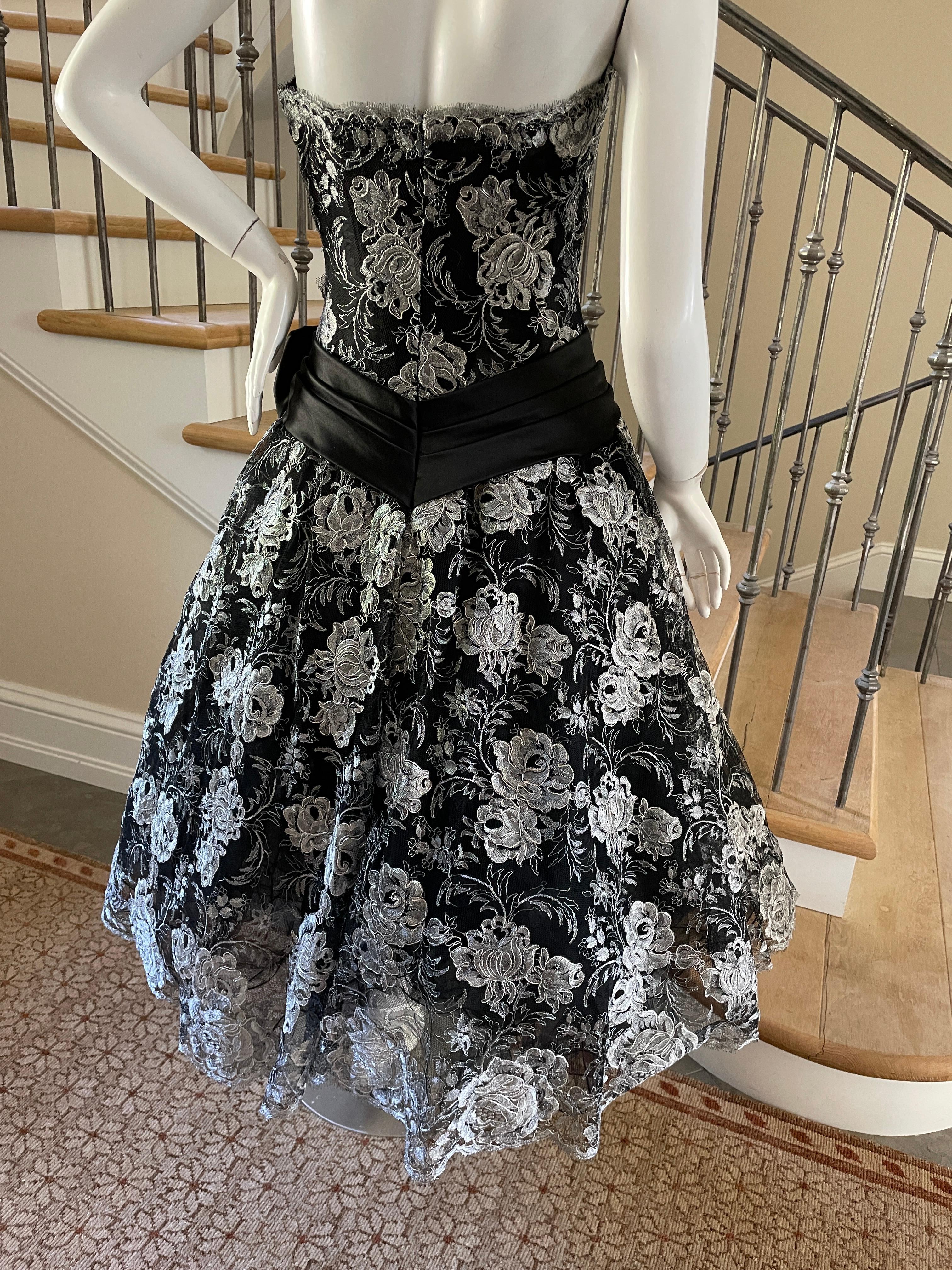 Vicky Tiel Couture Paris for Bergdorf Goodman Silver Lace Corset Cocktail Dress.
This is so pretty, metallic silver lace on black  tulle with a complete corset bust, with multiple petticoat skirts,
Size 40
 Bust 34