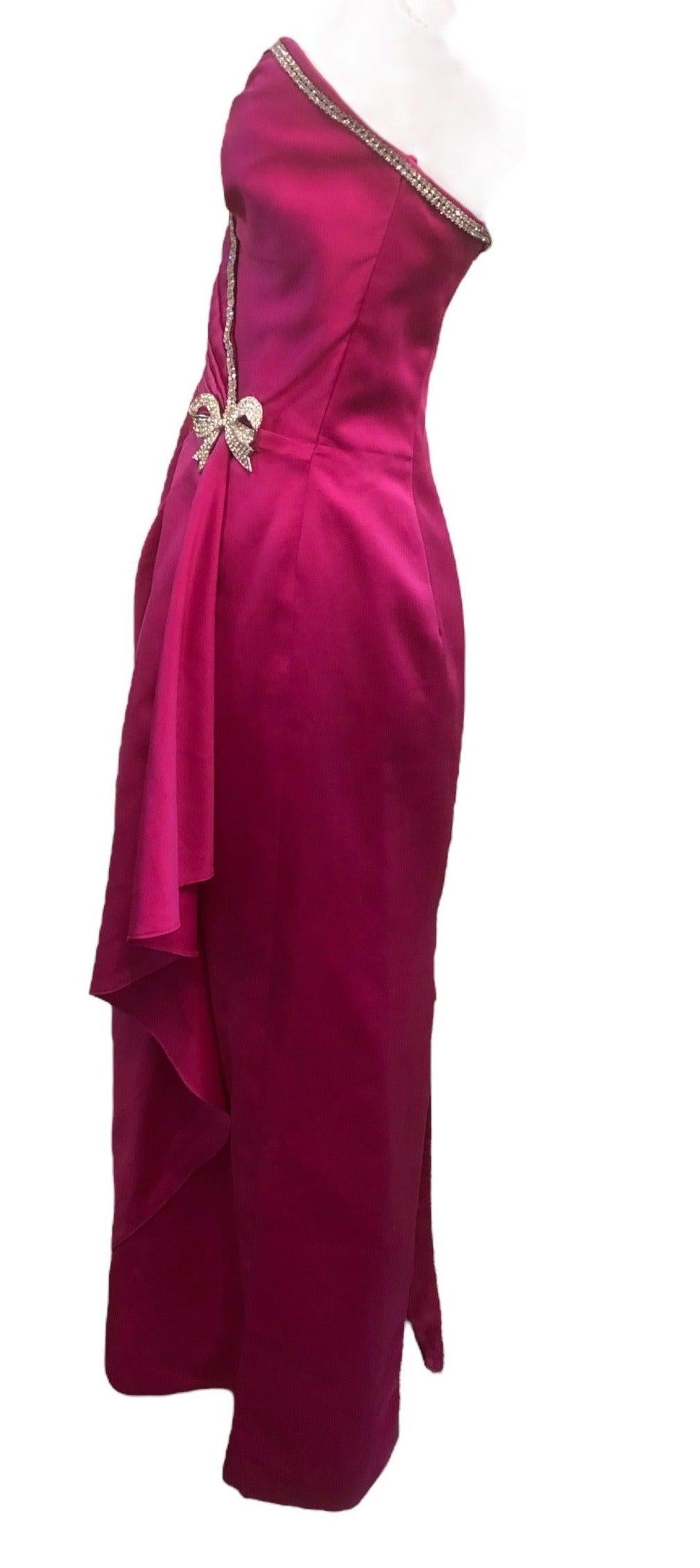 Questo splendido pezzo è stato realizzato dalla famosa stilista Vicky Tiel, che mette in mostra il suo stile unico dell'epoca dinamica degli anni Ottanta. Realizzato in raso fucsia, questo abito senza spalline emula un look glamour di Hollywood. Il