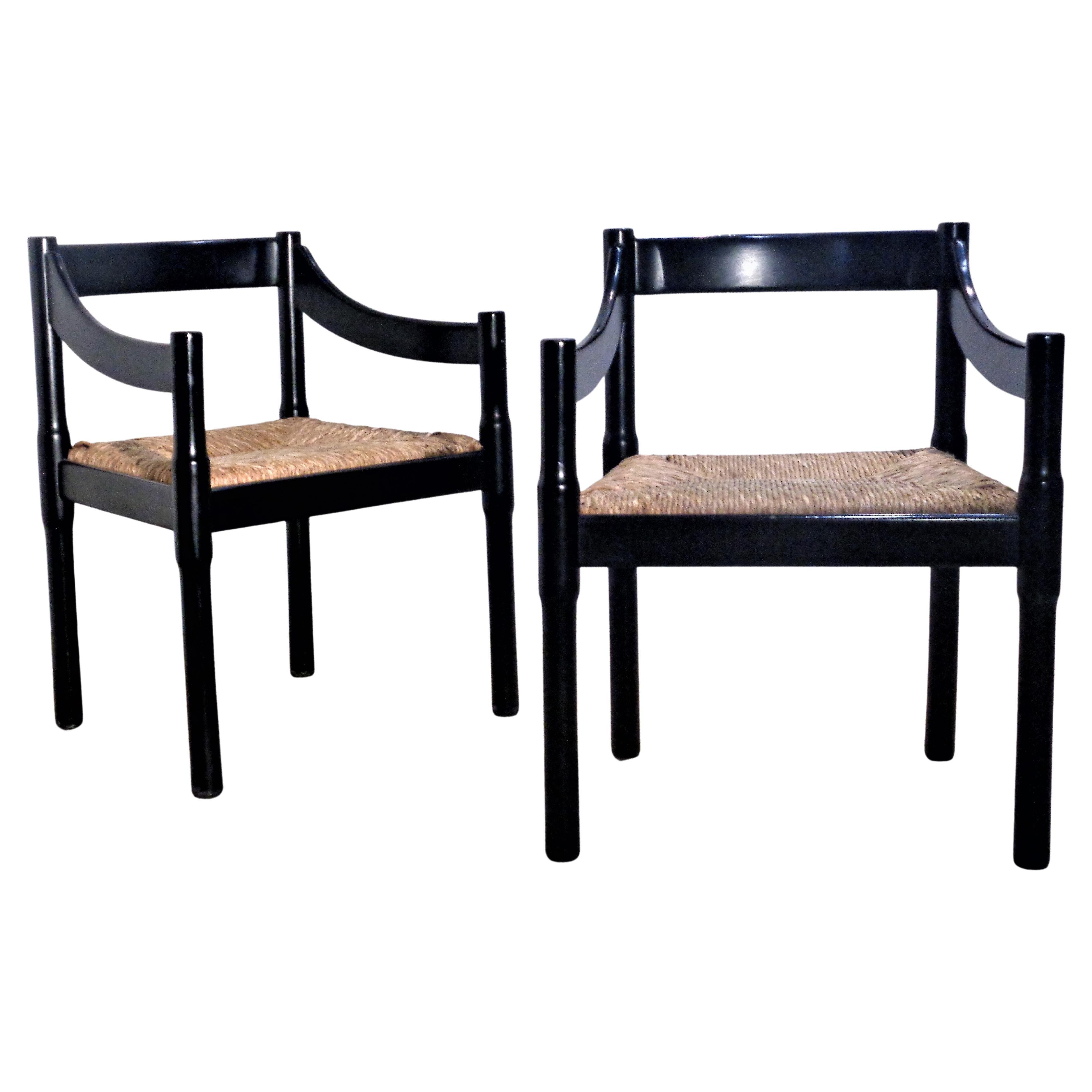 Vico Magistretti pair of model 'Carimate' dining chairs / armchairs in very good original black lacquered beech frames and natural woven rush seats. Made in Italy, circa 1960's. Look at all pictures and read condition report in comment section.