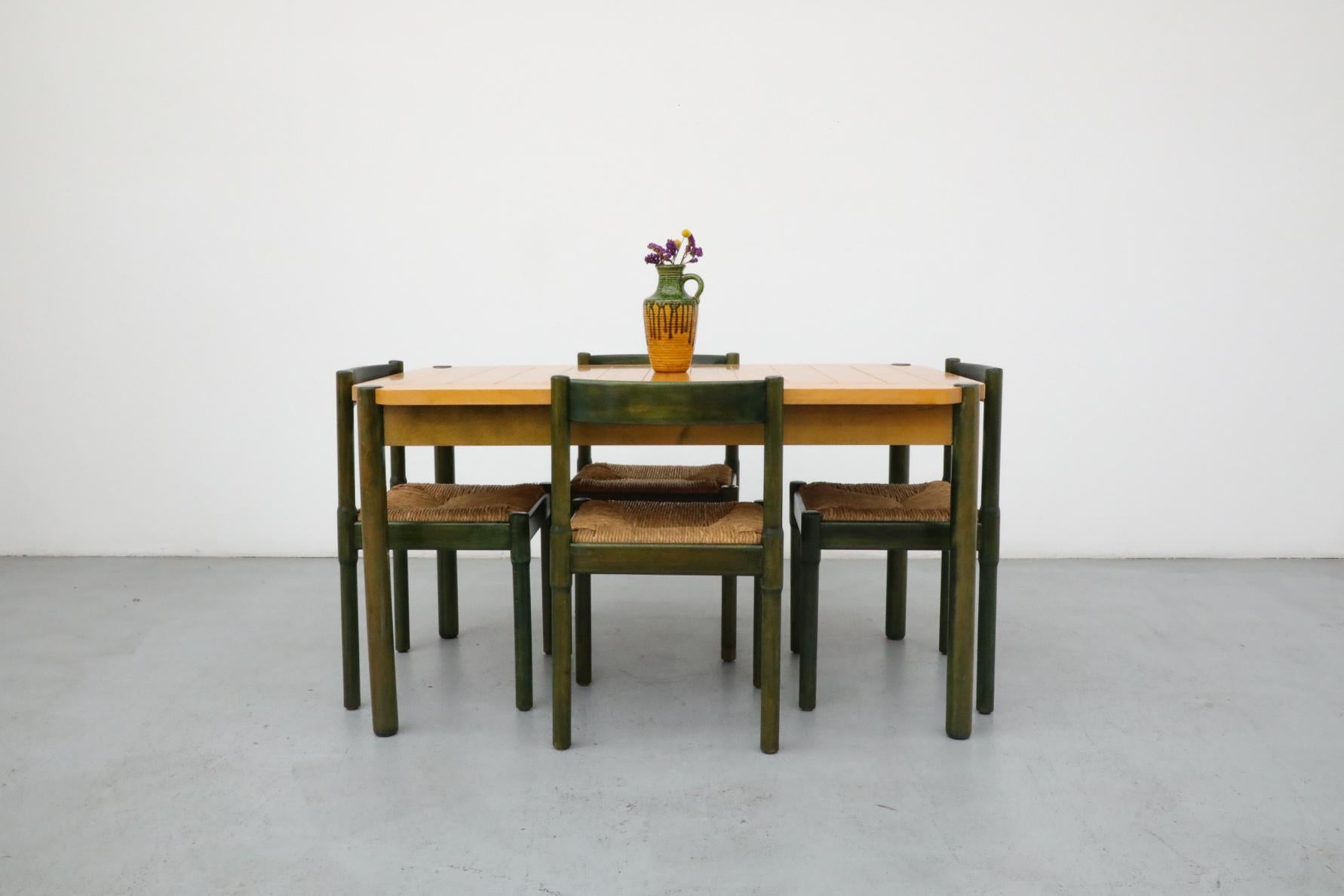 Cet ensemble de salle à manger se compose de quatre chaises de salle à manger Vico Magistretti, 'Carimate' en chêne teinté vert et d'une table de salle à manger assortie de style Loewenstein Padova des années 1970 avec un plateau en érable et un
