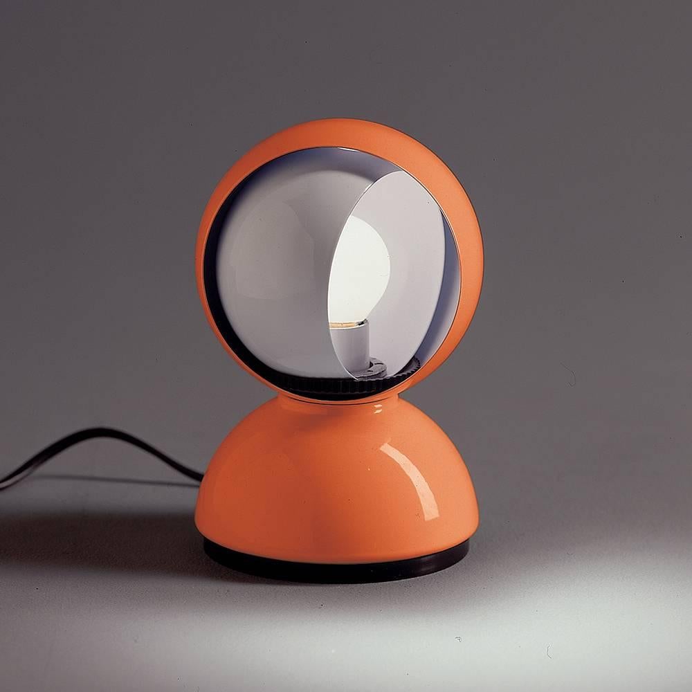 Vico Magistretti 'Eclisse' table lamp in orange for Artemide. 

Designed in 1967, the authorized re-edition Eclisse is a bedside table, or wall-mounted (pin-up), lamp for direct and diffused incandescent lighting. Body in lacquered steel, featuring