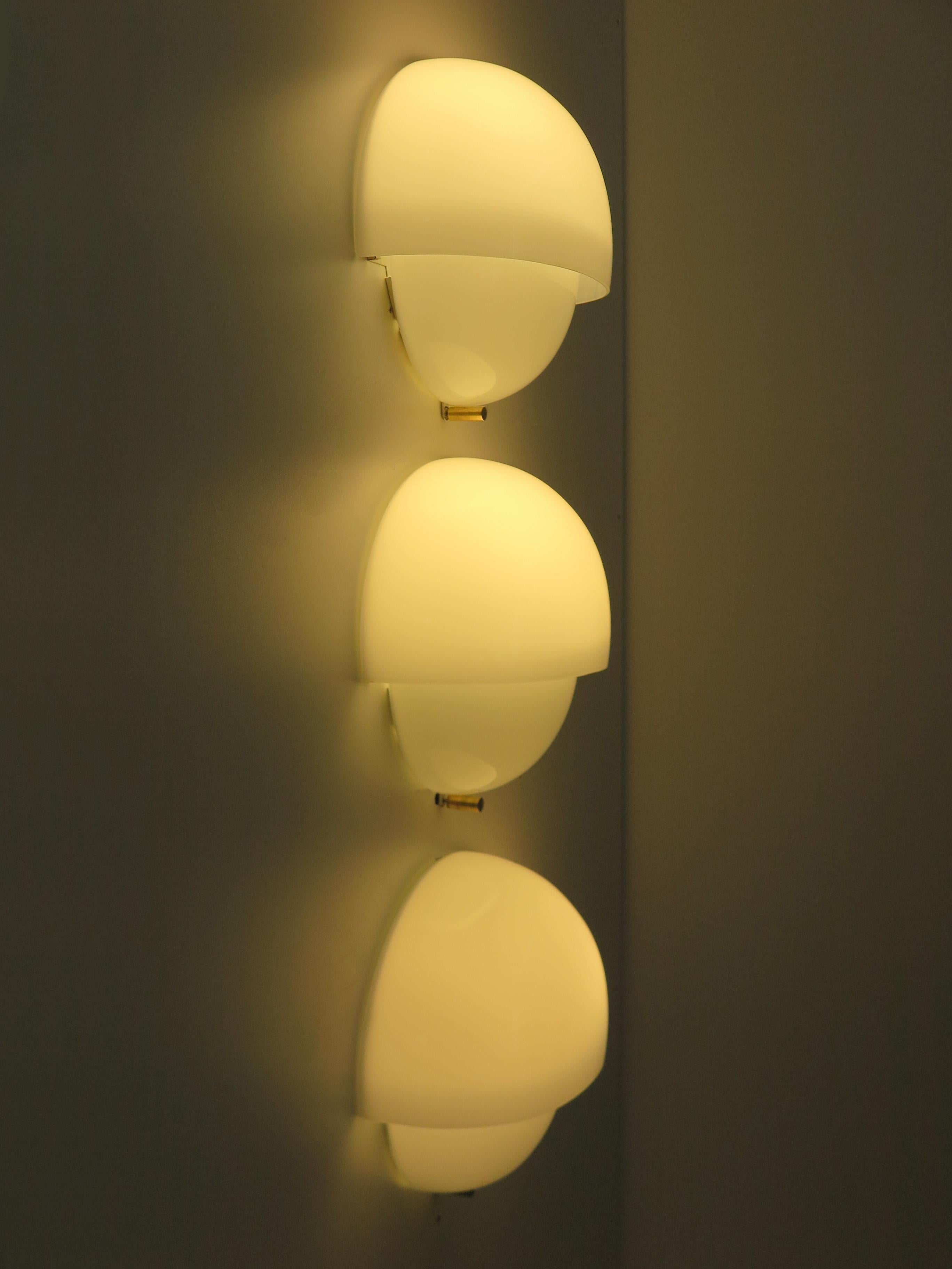 Set of three italian midcentury modern design sconces or wall lamps model Grande Mania designed by Vico Magistretti for Artemide in 1963 with Murano white glass models and brass detail, Italy 1960s
XIII Triennale.

Bibliography:
Coerenza nel design