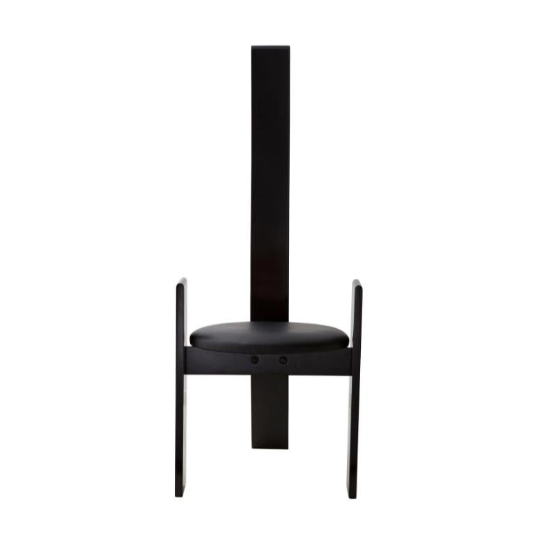 La chaise Golem du designer Vico Magistretti est une pièce d'art de haute qualité conçue par A LOT OF Brasil. Réalisée en bois avec une finition qui peut être en acajou ou en laque noire, l'assise est recouverte de cuir et ressemble davantage à une