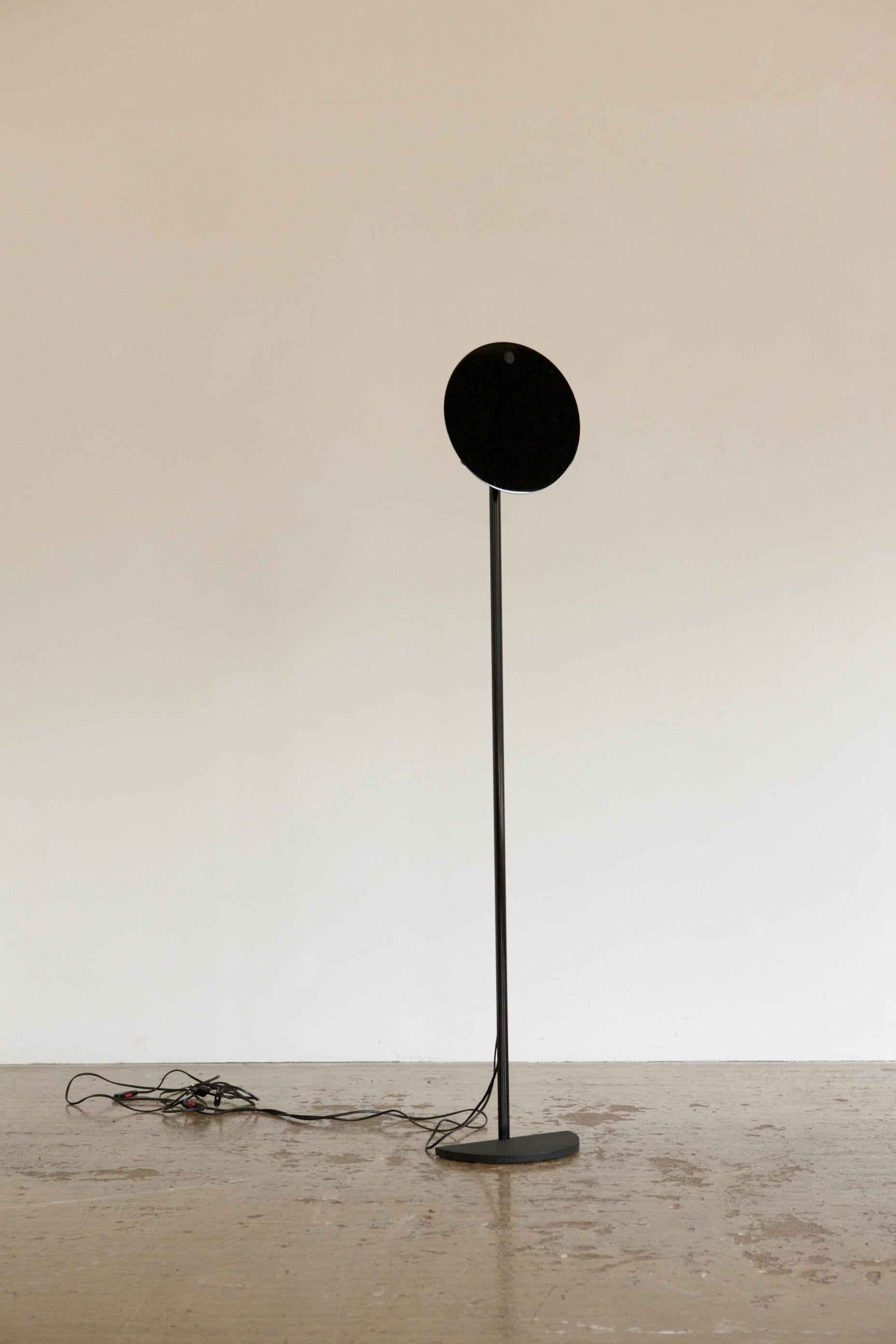 Floor lamp by Vico Magistretti. Designed for Oluce as part of the Idomeneo series. The modular lamp breaks down and features a floating black disk as a shade concealing a bulb holder. A very small dent in the disk can be viewed in 5th picture.