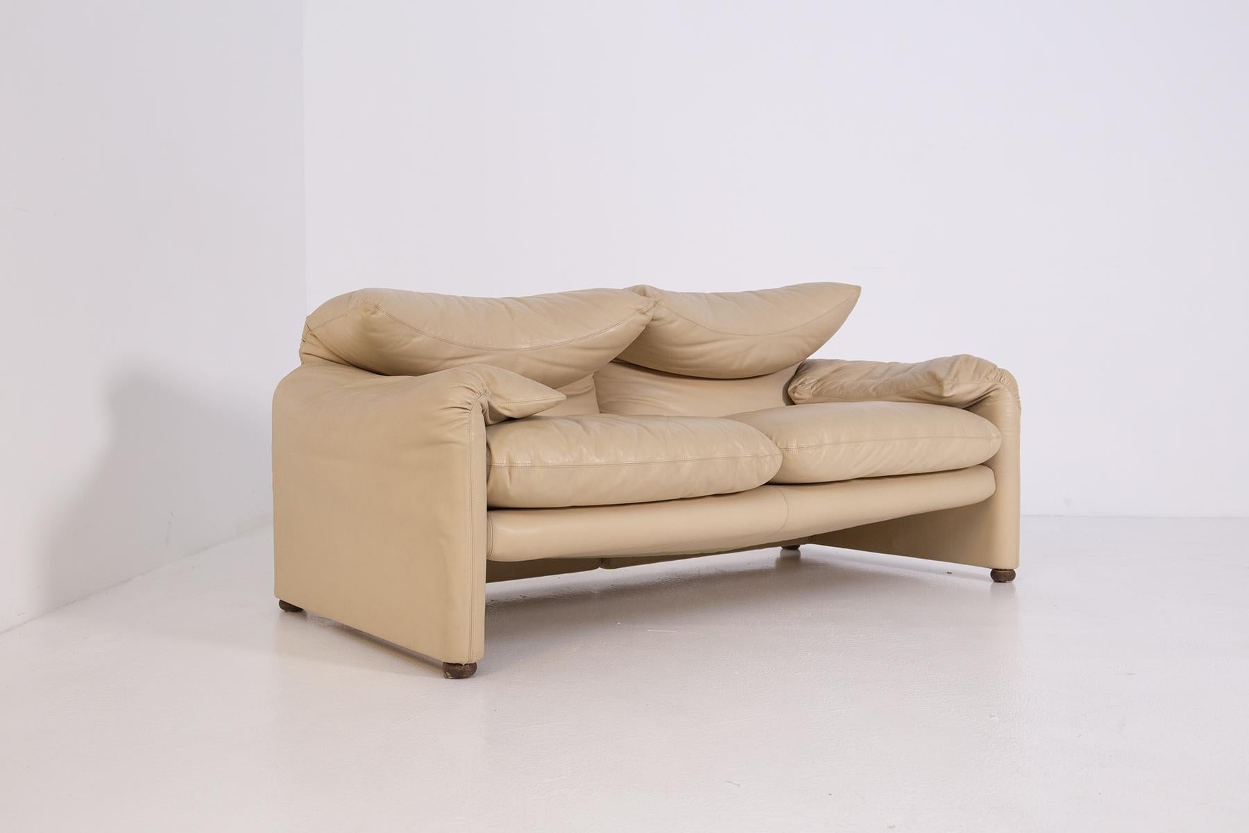 Sofa designed by Vico Magistretti for the Cassina and Busnelli factory in the 1970s. The two-seater sofa is upholstered entirely in light beige leather. With its warm and reassuring shapes, where the possibility of movement of the backrest, the soft