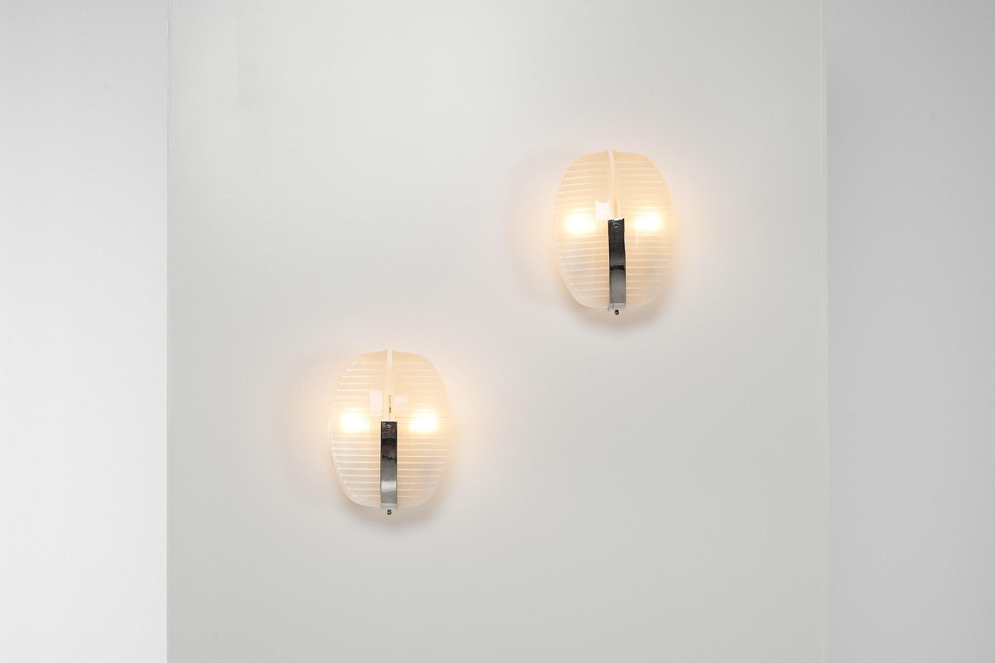 Nice industrial looking set of wall lamps model 'Lambda' designed by Vico Magistretti and manufactured by Artemide, Italy 1961. These lamps have a chrome and nickel-plated structure, which connects 2 nicely shaped, pressed crystal glass diffuser