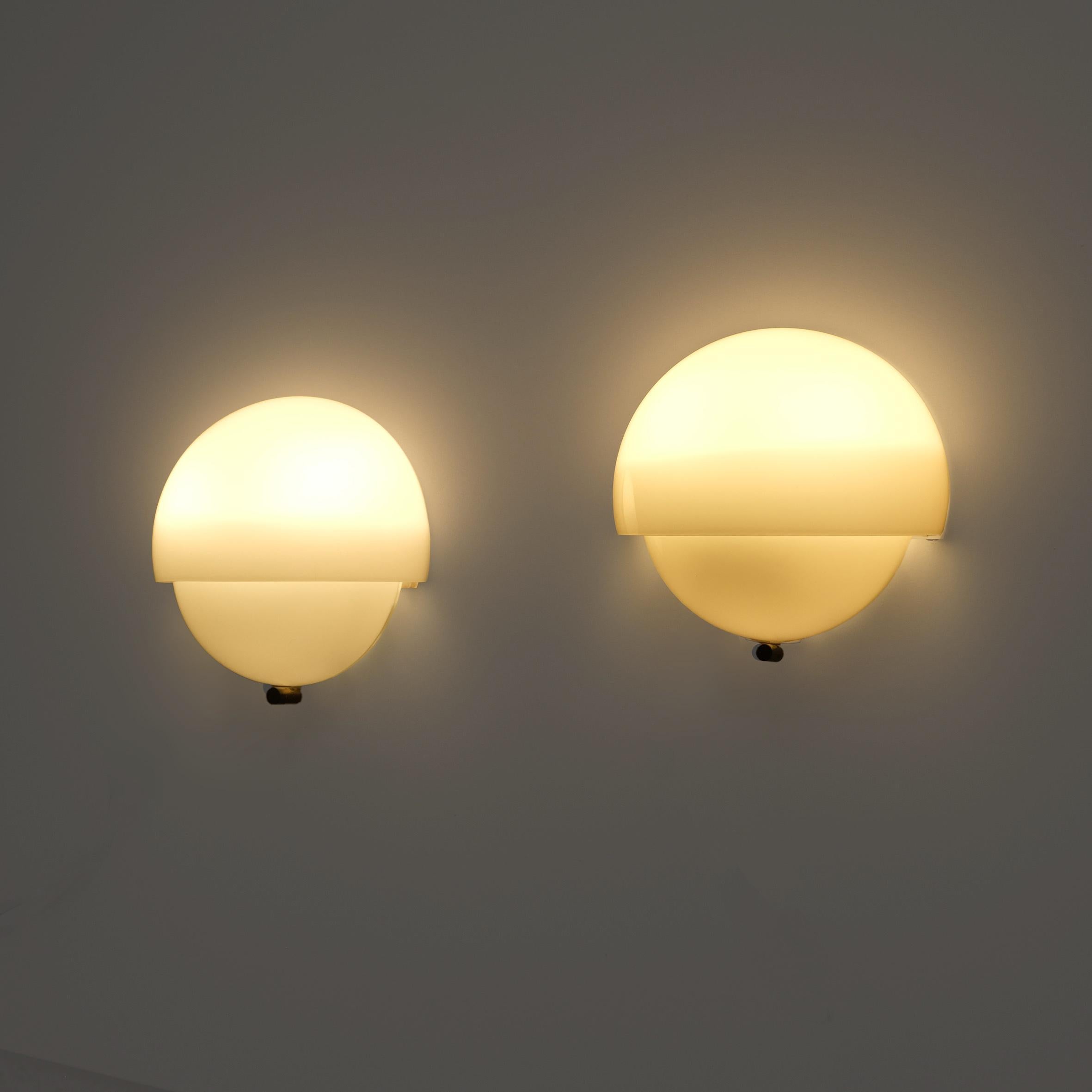 Vico Magistretti (1920-2006)

Manía

Par de apliques de cristal blanco, cada uno de ellos formado por dos tulipas superpuestas de cristal opalino de distinto tamaño, montadas sobre un marco redondo de metal blanco.
Producido por Artemide,