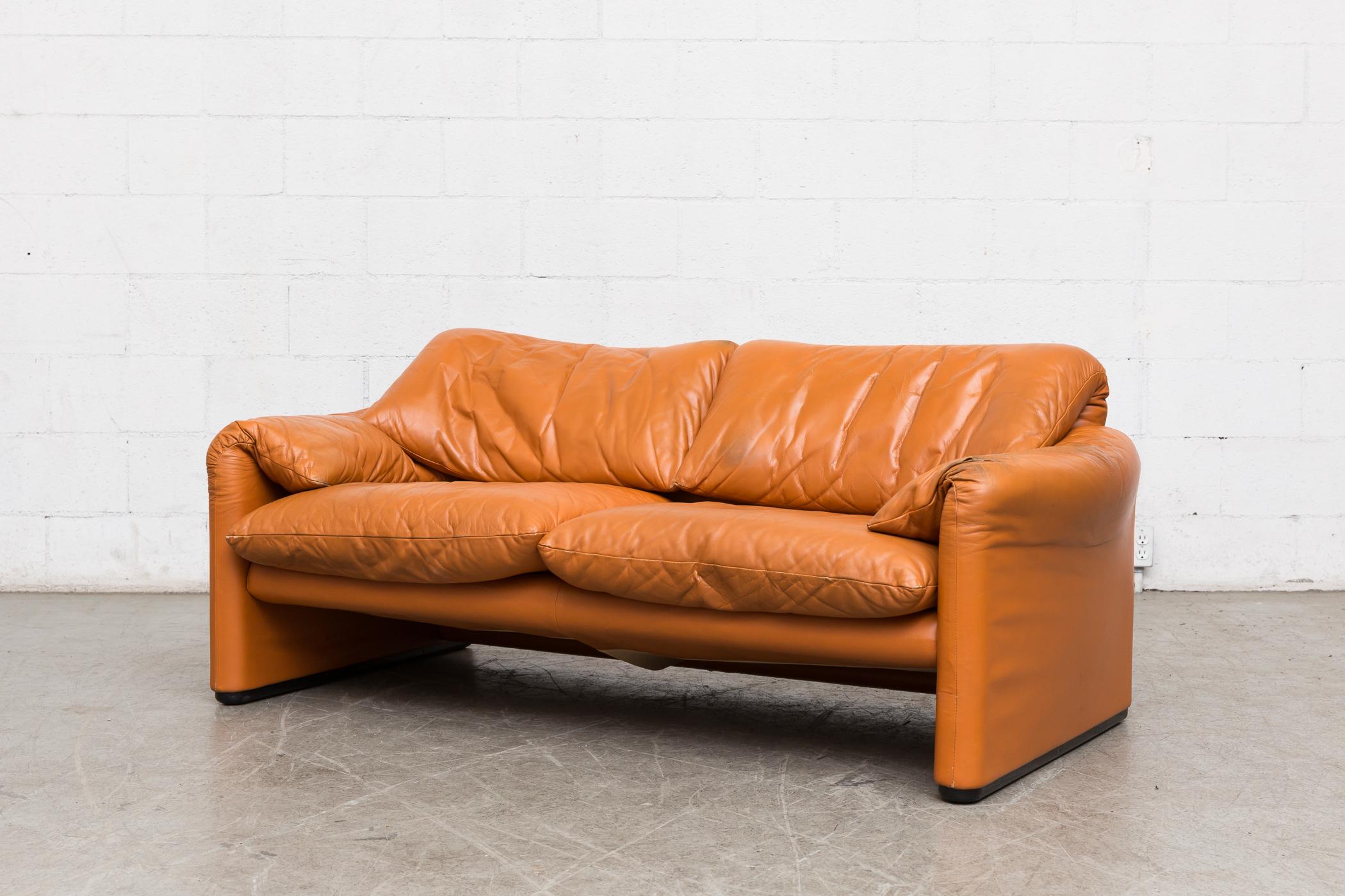 Vico Magistretti Maralunga caramel leather loveseat with fold-over cushion design. Nice patina with visible wear to the leather, some color loss. Wear consistent with age and use.