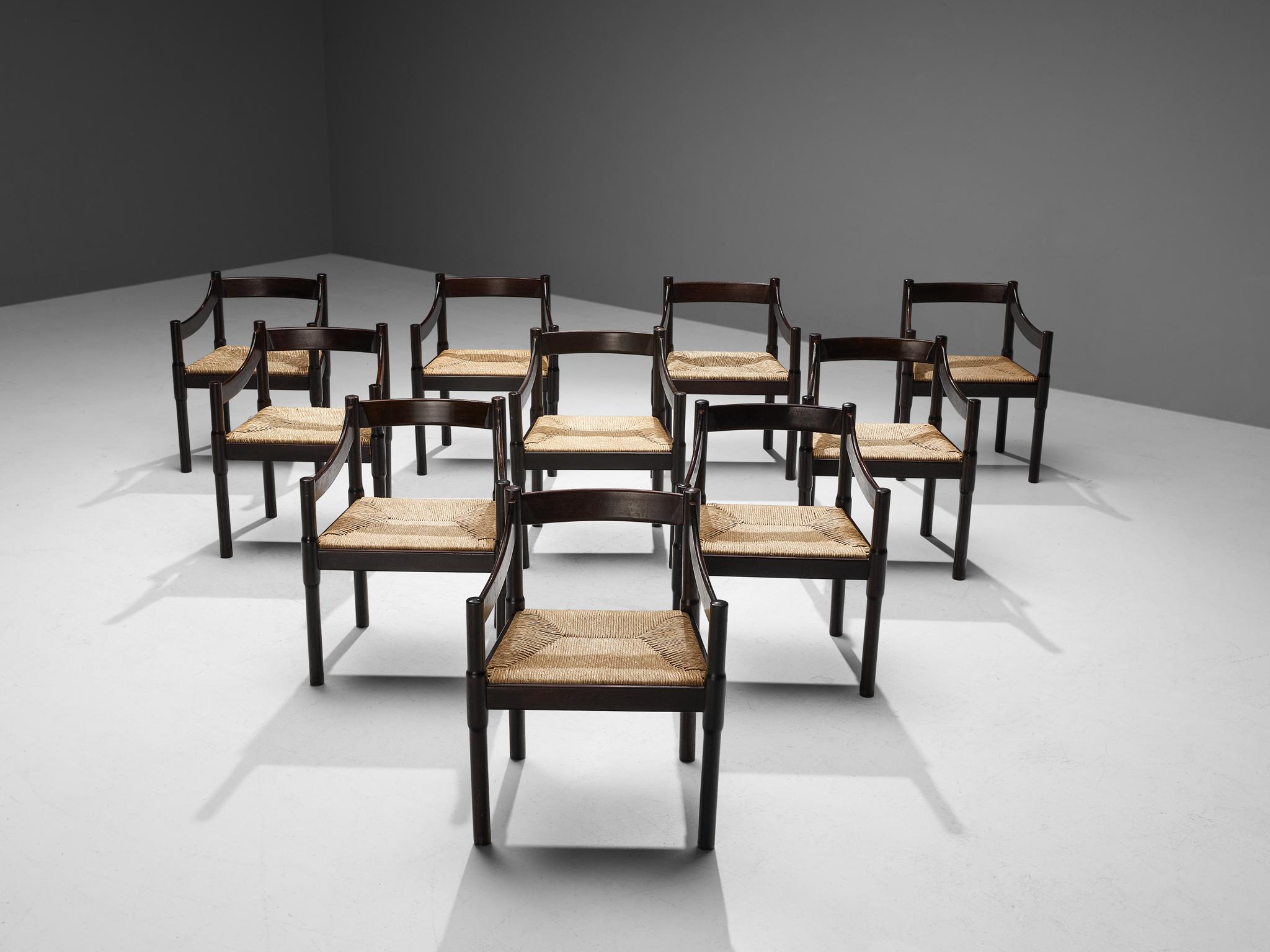 Vico Magistretti, ensemble de dix chaises de salle à manger modèle 'Carimate', hêtre teinté, osier paille, Italie, conçu vers 1960.

La chaise 