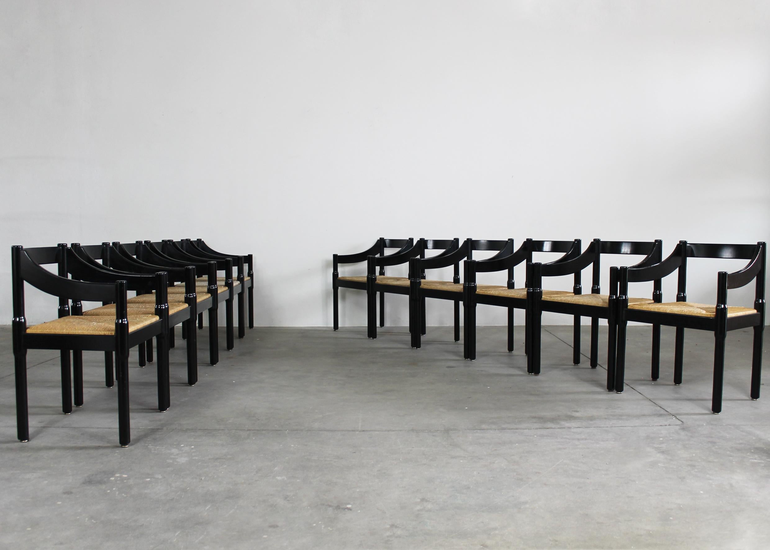 Set of twelve Carimate chairs with structure in black lacquered beech wood and woven straw seat, designed by Vico Magistretti and produced by Cassina in the 1960s. 

The Carimate chair was originally designed for the Carimate Club House in Como in