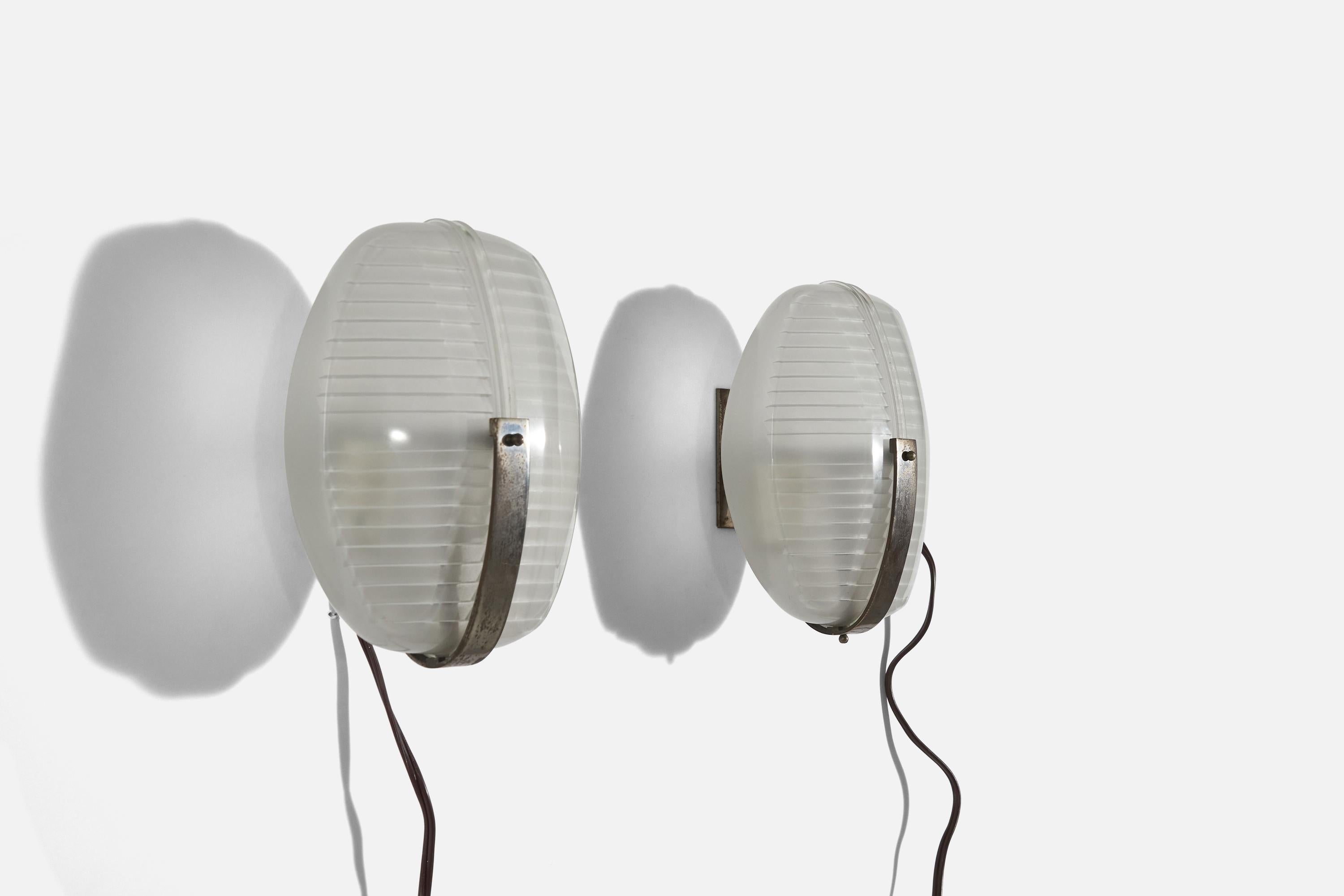 A pair of metal and glass wall lights designed by Vico Magistretti and produced by Artemide, Italy, 1960s.

Please note lamps are configured for hardwire.

Dimensions of back plate (inches) : 3.875 x 1.8125 x 0.125 (H x W x D).