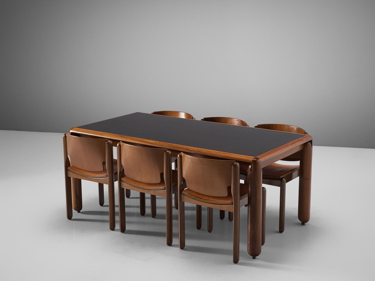 Vico Magistretti for Cassina, dining set, walnut and leather, Italy, circa 1967.

Sculpted dining set consisting of a rectangular shaped table and 6 dining chairs, designed by Vico Magistretti. The chairs feature half cylindrical legs, that are