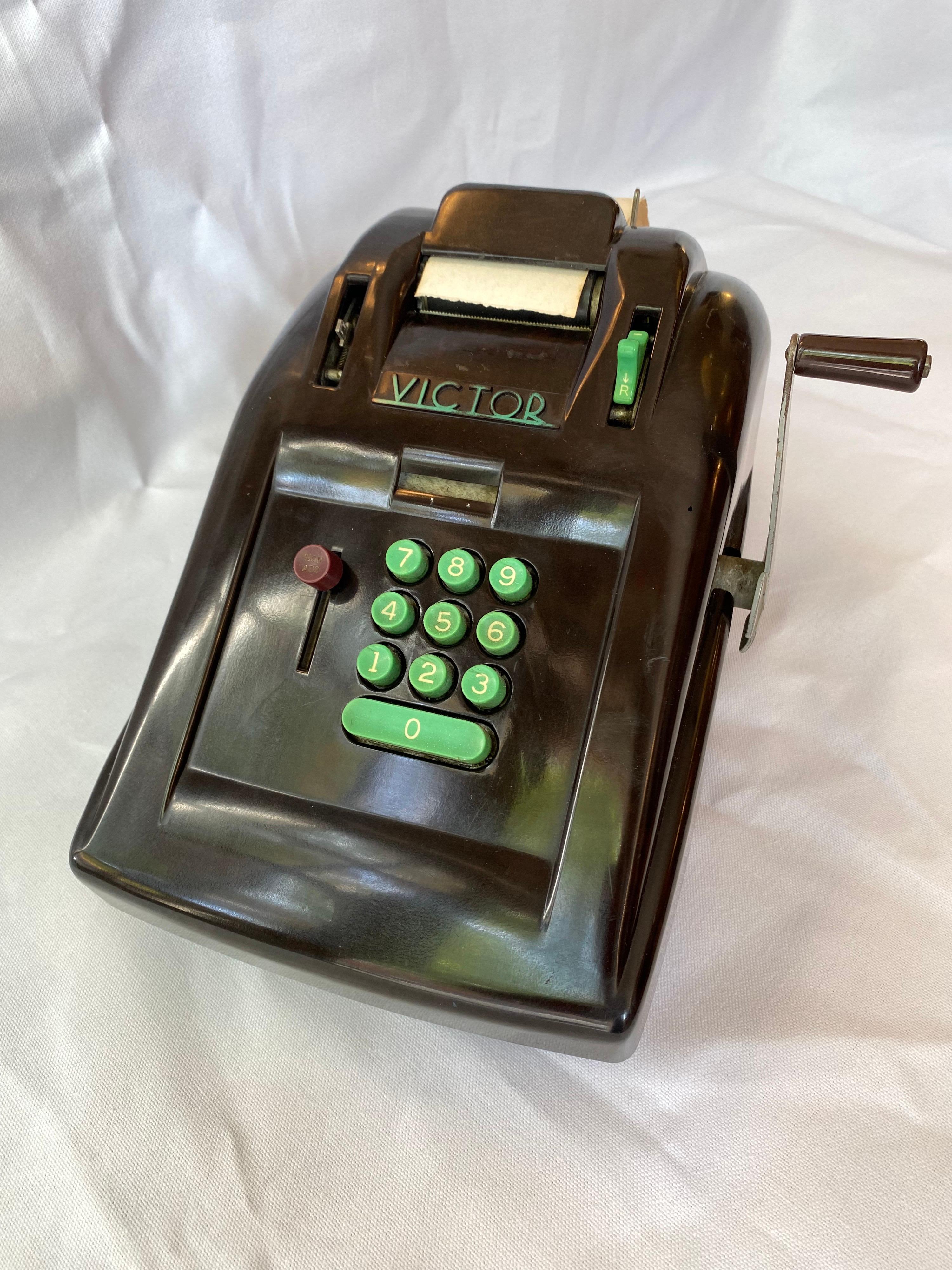 Victor Bakelite Adding Machine. Machine Age, Streamlined Design makes this a Classic of the Period! Designed in 1937 in Bakelite. Dark Brown Bakelite Body with Green keys. Missing one knob, as seen in photos, but still a great looking Art Deco