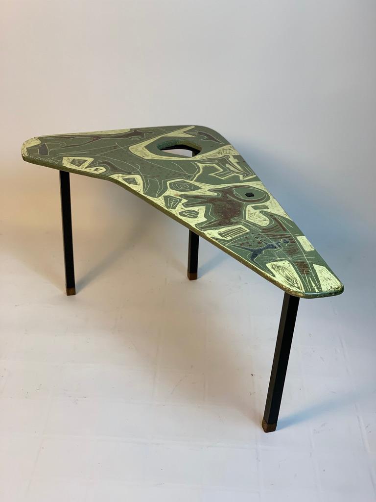 Coffee table unique piece by Master Ceramist Victor Cerrato Turin Italy 1950's with ceramic top decorated with scenes inspired by prehistoric graffiti from the typical 50's perforated Boomerang shape. Legs in black lacquered metal and wooden feet.