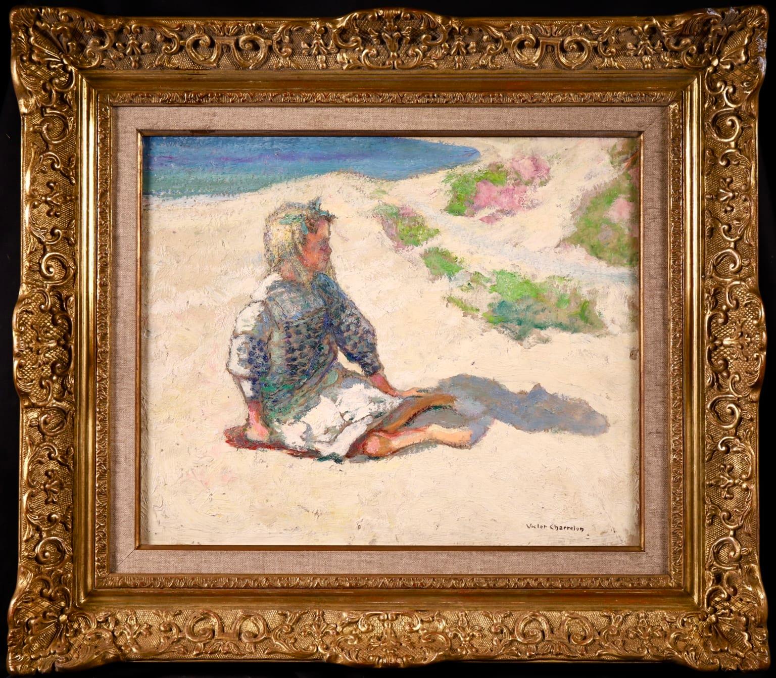 A stunning oil on board circa 1910 by sought after French post impressionist painter Victor Charreton, who was known as the painter of colours. The piece depicts a young girl in a blue and white dress and a bow in her hair sitting barefoot on the