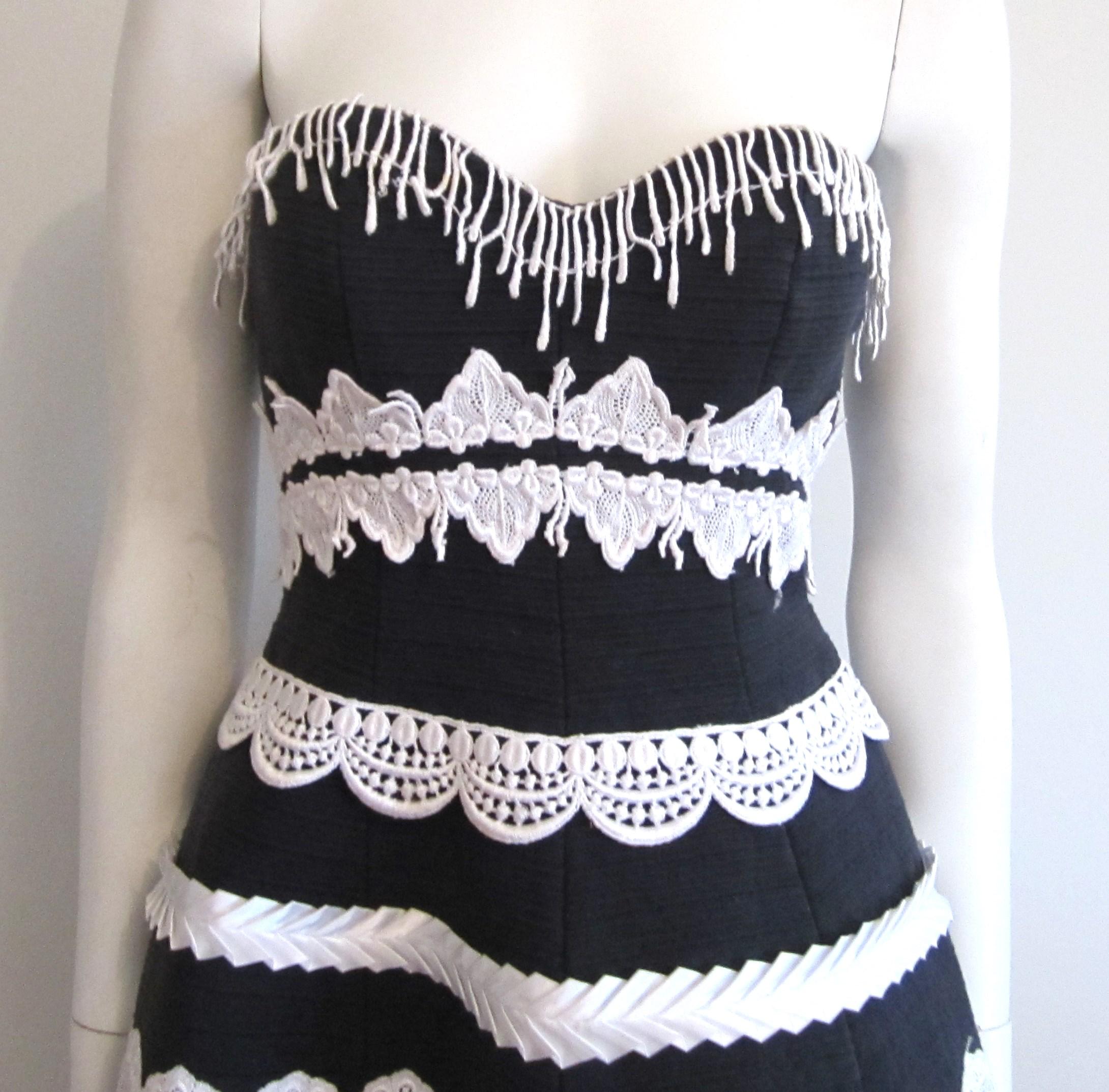 Sexy trägerloses schwarzes Cocktailkleid von Victor Costa mit weißer Schleife und Verzierungen.  Victor Costa für Saks Fifth Avenue. Das trägerlose Kleid hat ein tailliertes Mieder. Der volle Rock ist mit weißem Satinband und Soutache verziert. Hat