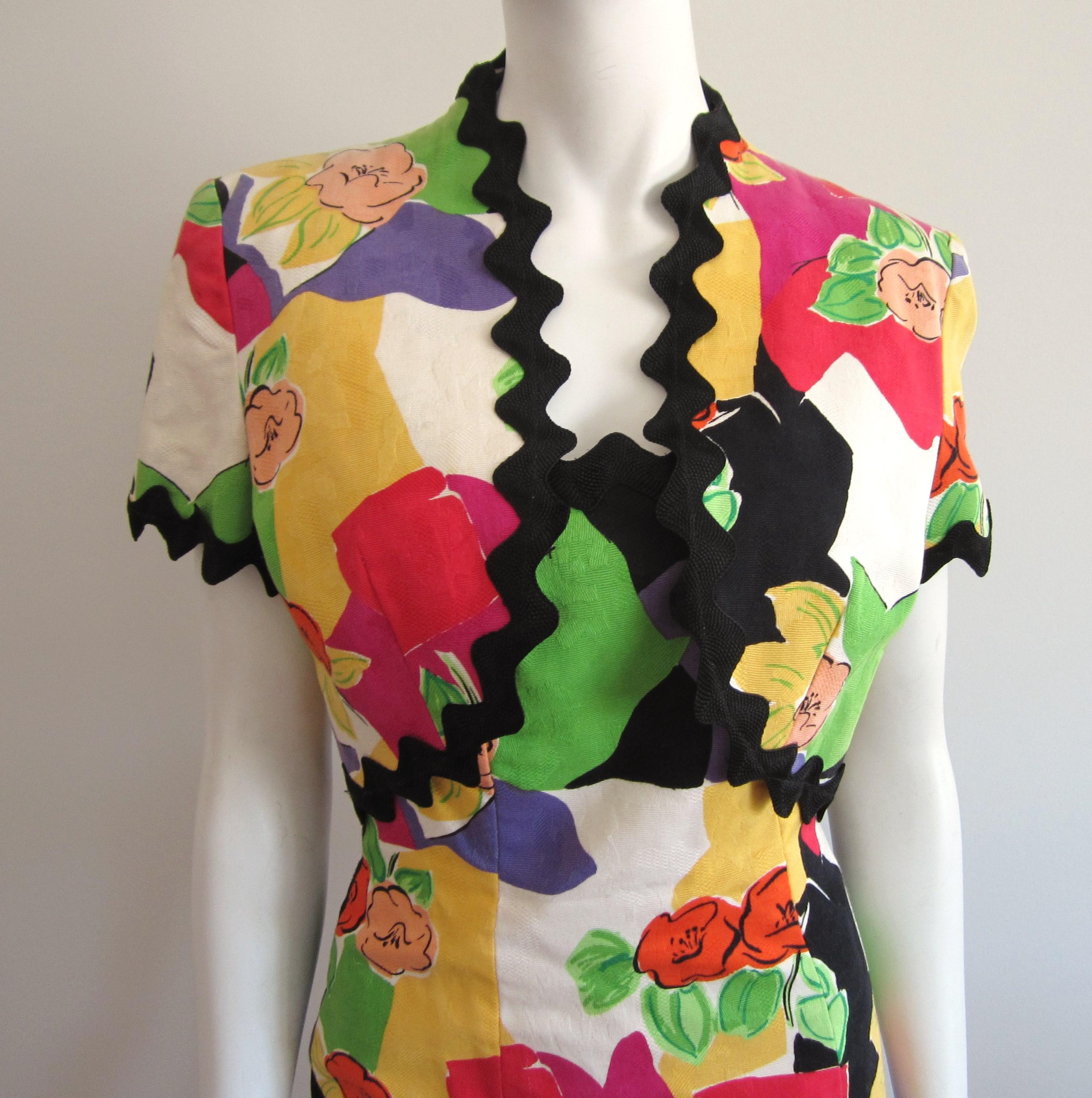 Ready for spring and summer! This has stunning colors in it! Yellow, green, peach, red, and more. Strapless dress with a matching bolero jacket. Rick Rack trim around top and bottom of dress and on jacket. Zips up the back. Both, jacket and dress