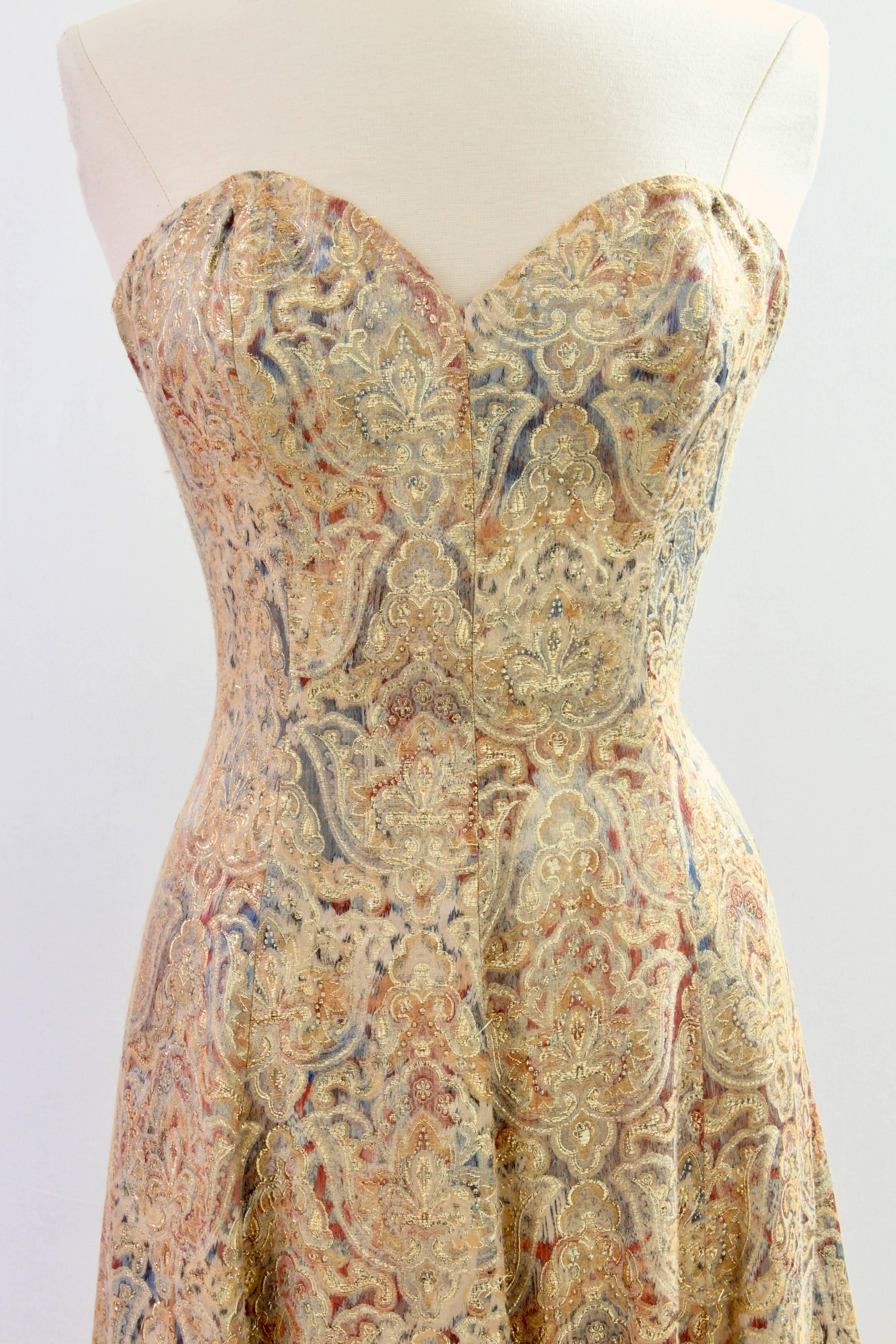 This pretty evening gown was made by Victor Costa for Neiman Marcus, most likely in the 1990s.  Made from a linen blend floral brocade with gold lurex thread detailing, it fastens with an inner corset and rear zipper and is fully-lined.  In good