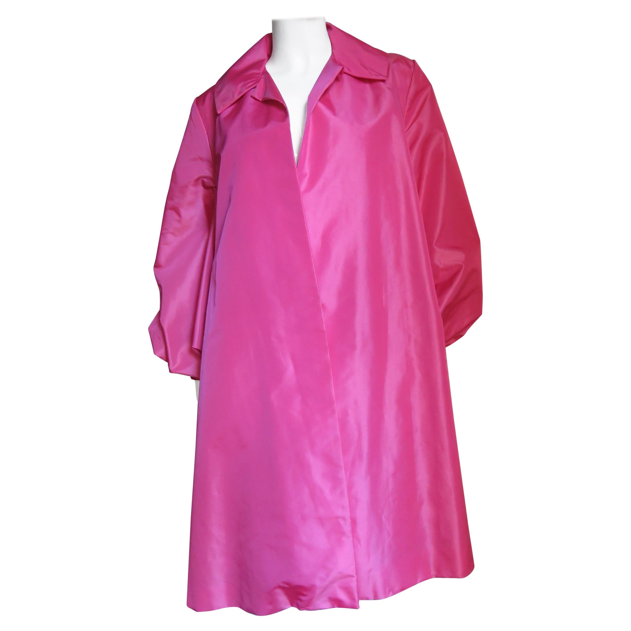 A fabulous bright pink coat from Victor Costa. It is swing style open front without closures and  balloon sleeves with cuffs.  The back is spectacular with 2 gathered tiers starting from the back yoke each wider and fuller than the other flaring