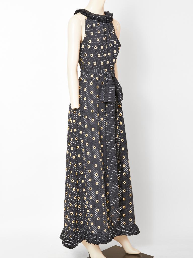 Victor Costa Romantica, dotted swiss maxi dress having white dots, on a black voile background, halter cut sleeves, and a pleated ruffle collar. The dress is gathered at the waist with a self tie. Hem has same pleated ruffle detail as the neckline.