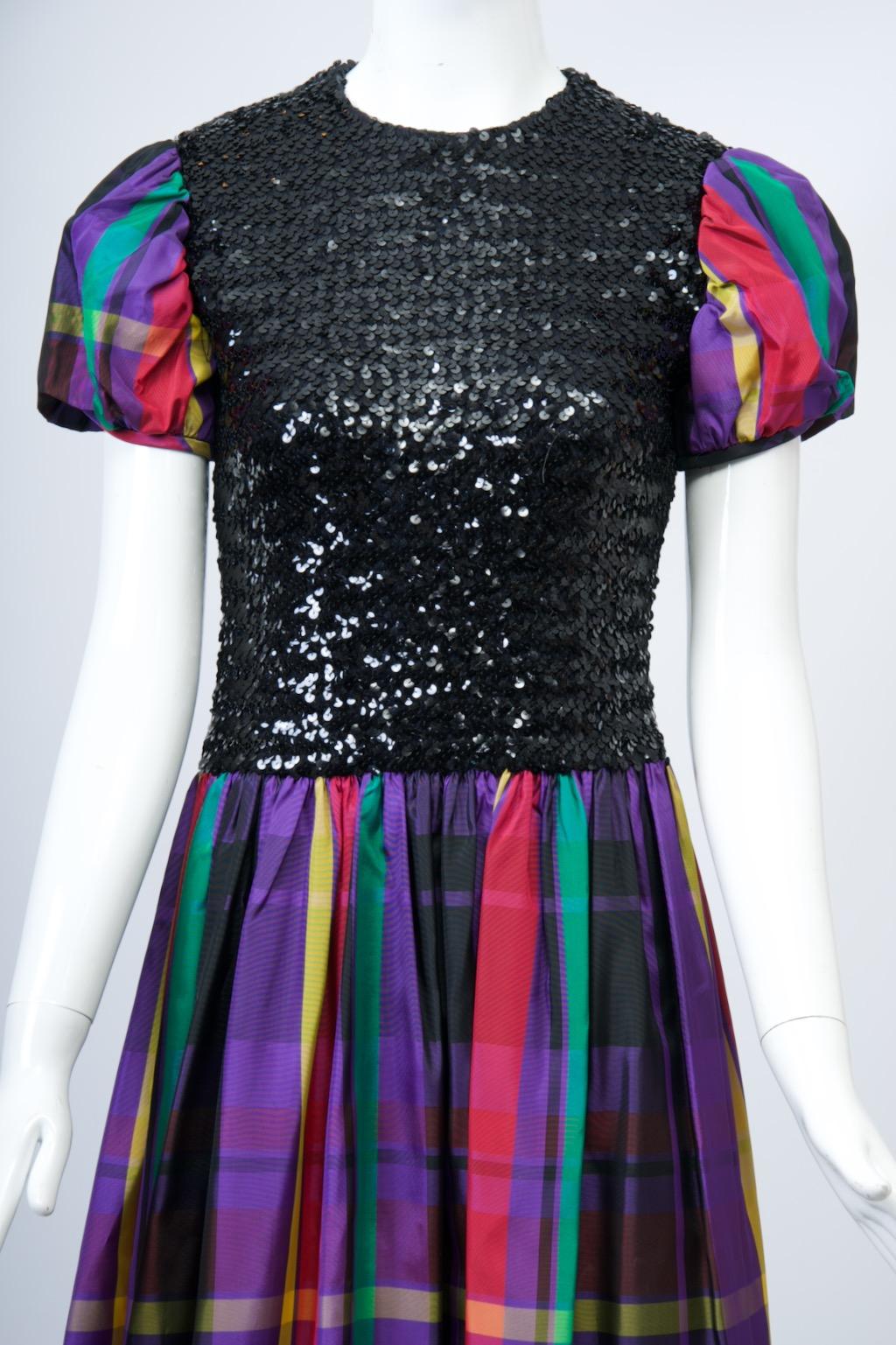 c.1970 Victor Costa for Romantica long dress combining a black sequin bodice juxtaposed with a large-scale taffeta plaid for the full ankle-length skirt and short puffed sleeves, a nice riff on high/low fashion. The shell-shaped bodice, which is