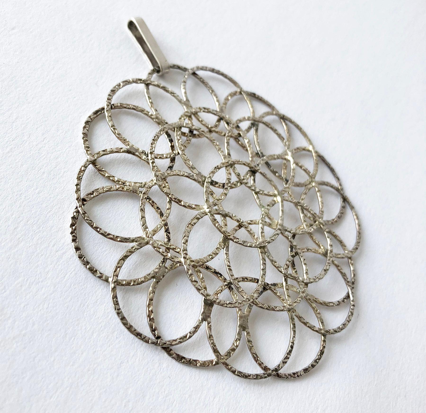 Sterling silver circular lacy pendant created by Victor Janson of Sweden, circa 1970's. Pendant measures 3