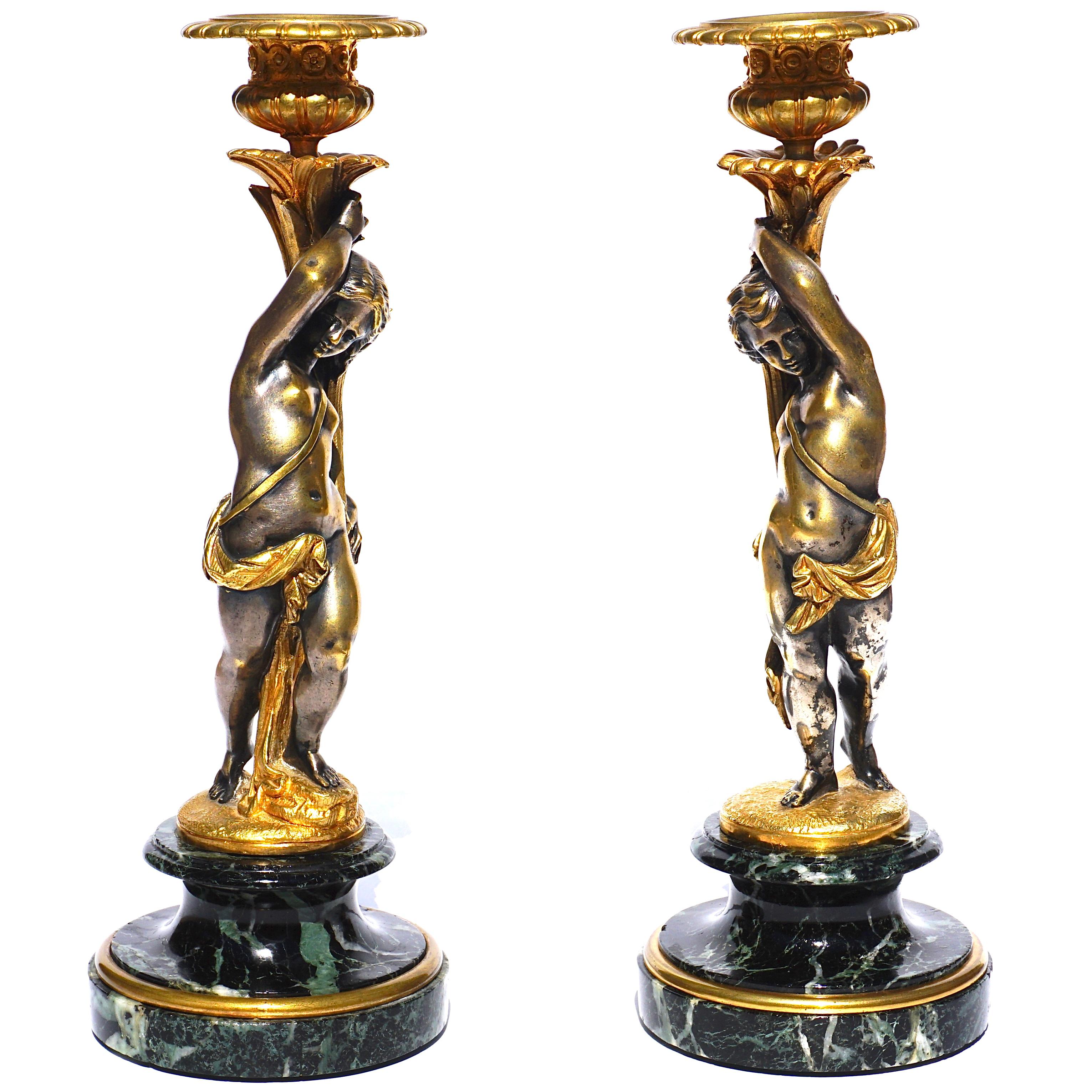 A French 19th century detailed pair of silvered bronze candelabras by Victor Paillard. In the classical and Louis XVI style is a nude woman and man draped carrying ornate torches. The nude figures with traces of slivering and drapes and torches gilt