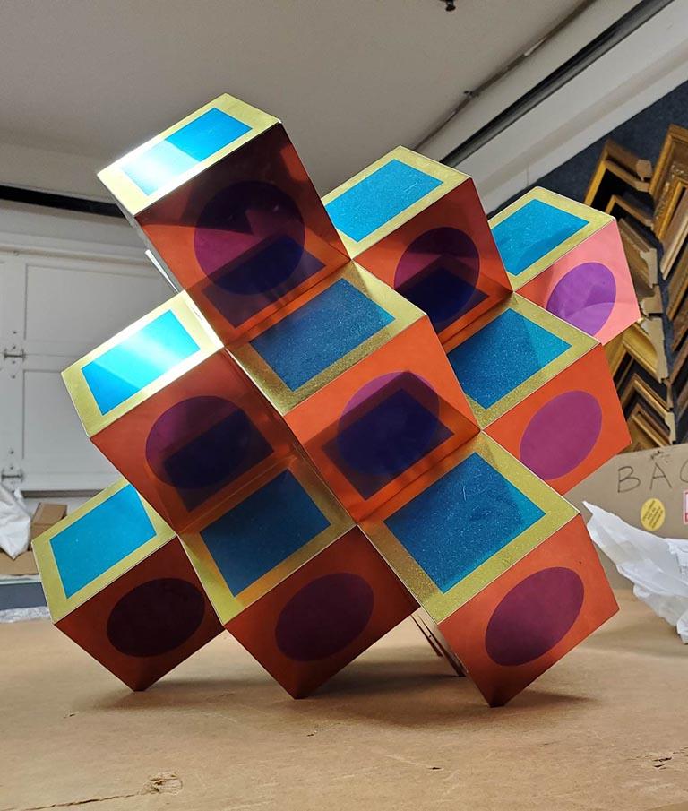 Similar to its cousin, Kroa A, this work is of the same basic structure and form, with different coloration throughout. The faces of the sculpture denote a distinct idea of planes and sides; each side is colored in dual tones, keeping a vague