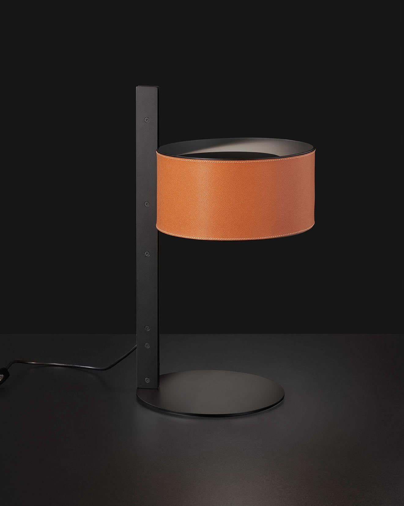 Table Lamp model Parallel designed by Victor Vasilev in 2022.
Table lamp in metal giving direct light. Base, stem and closing disk in lacquered matt black, reflector covered with leather. With universal dimmer.
Manufactured by Oluce,