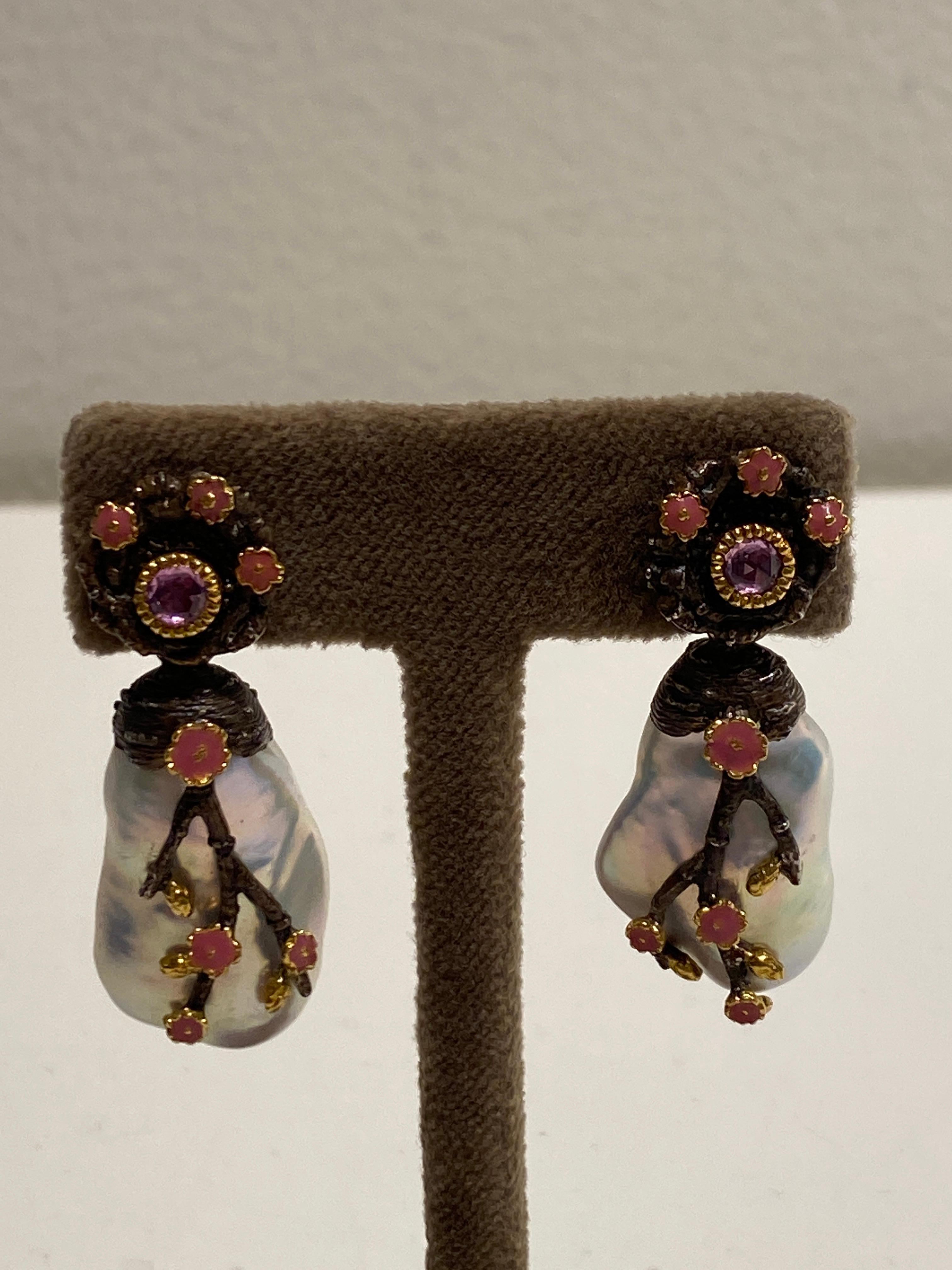 Inspired by the energy pulsating throughout nature, Velyan unites pure metals and gemstones into stunning styles that display the grandeur of fine jewelry.

These earrings feature freshwater pearls with pink sapphires set in yellow gold and patina