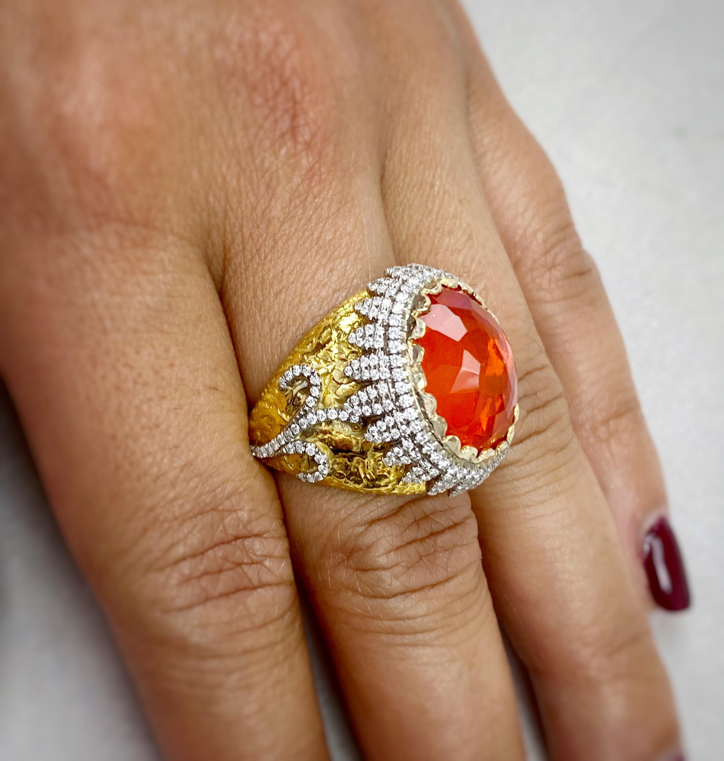 This exquisite Fire Opal and Diamond Ring features a 5.79 carat Mexican Fire Opal accented with 1.11 carats of fully faceted Diamond accents. The Fire Opal is reverse set in this hand made setting of hammered, solid 18K yellow Gold and 18k white