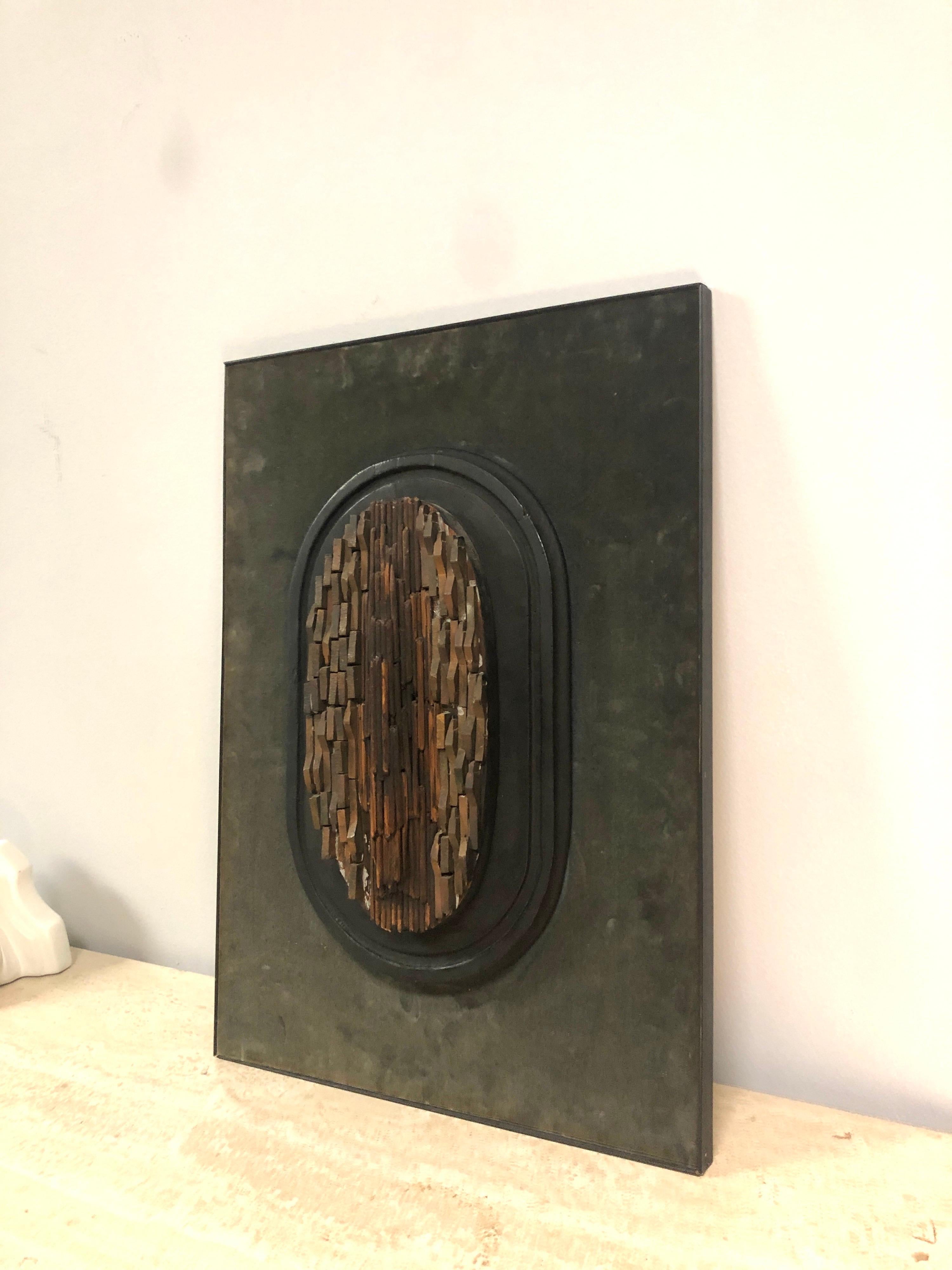 A wall sculpture by well known Belgian artist Vic Gentils. It is wood, metal, and ceramic pieces arranged on a wood oval, which is mounted on a velvet covered board with makeshift frame. Quite interesting in a raw, organic intuitive way. Can't take