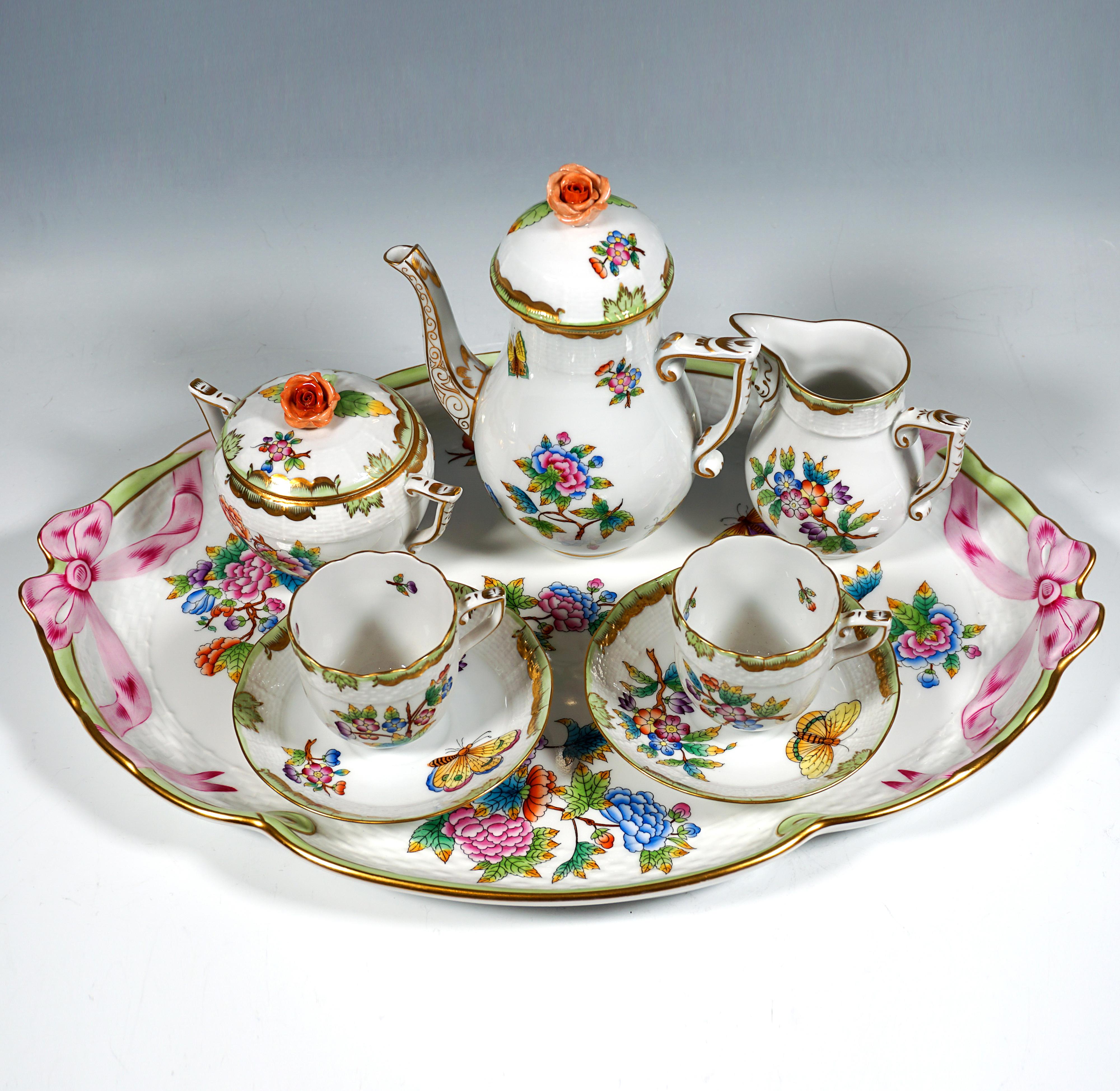 Servicio Herend, compuesto por 8 piezas: olla moka con tapa, lechera, azucarero, dos tazas, dos platillos y plato grande de servir.
Forma:   Mimbre / Mimbrera
Decoración:  VBO - Victoria avec Bord en Or - profusamente decorada con mariposas y ramas