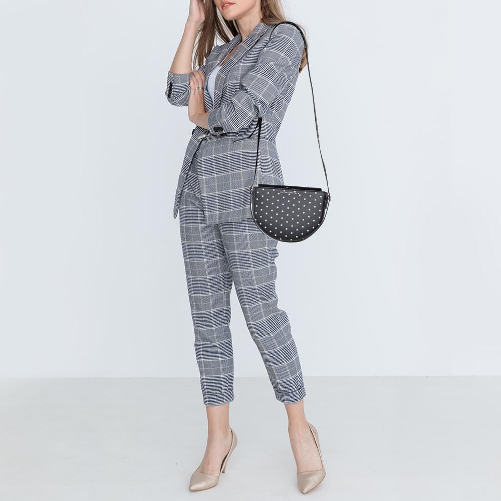 It is a stylish and functional leather bag that adds a harmonious finish to any appearance. The suede lining of this bag makes it all the more durable. Designed by Victoria Beckham, the Baby Half Moon shoulder bag has polka dots all over the