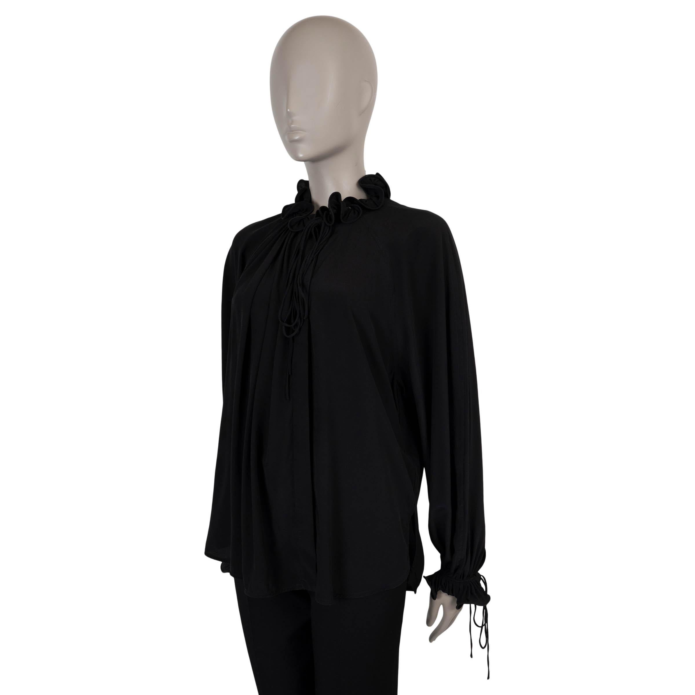 Questa camicetta di Victoria Beckham, autentica al 100%, è realizzata in crepe di seta nera per un drappeggio fluido e una sensazione di lusso. Il design è caratterizzato da una silhouette rilassata con scollo e polsini con coulisse che conferiscono