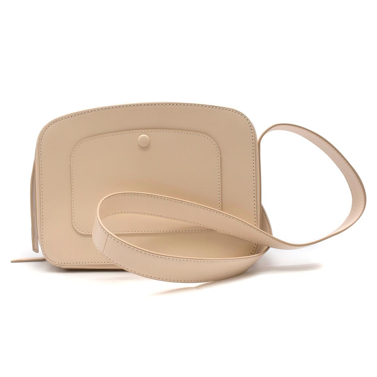 Victoria Beckham Cream Vanity Camera Bag

- Cream leather camera bag
- Front logo embroidered on the side
- Adjustable shoulder strap
- Dual zip around closure
- Black leather lining
- Interior pocket
- Exterior back pocket with snap button