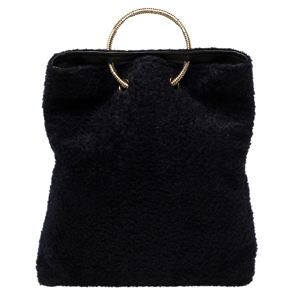 Sprinkle grace and style in every swing with this lovely clutch from Victoria Beckham. Crafted from dark blue shearling, the clutch has a sophisticated silhouette and is held by a gold-tone spiral handle. The insides are lined with leather and they