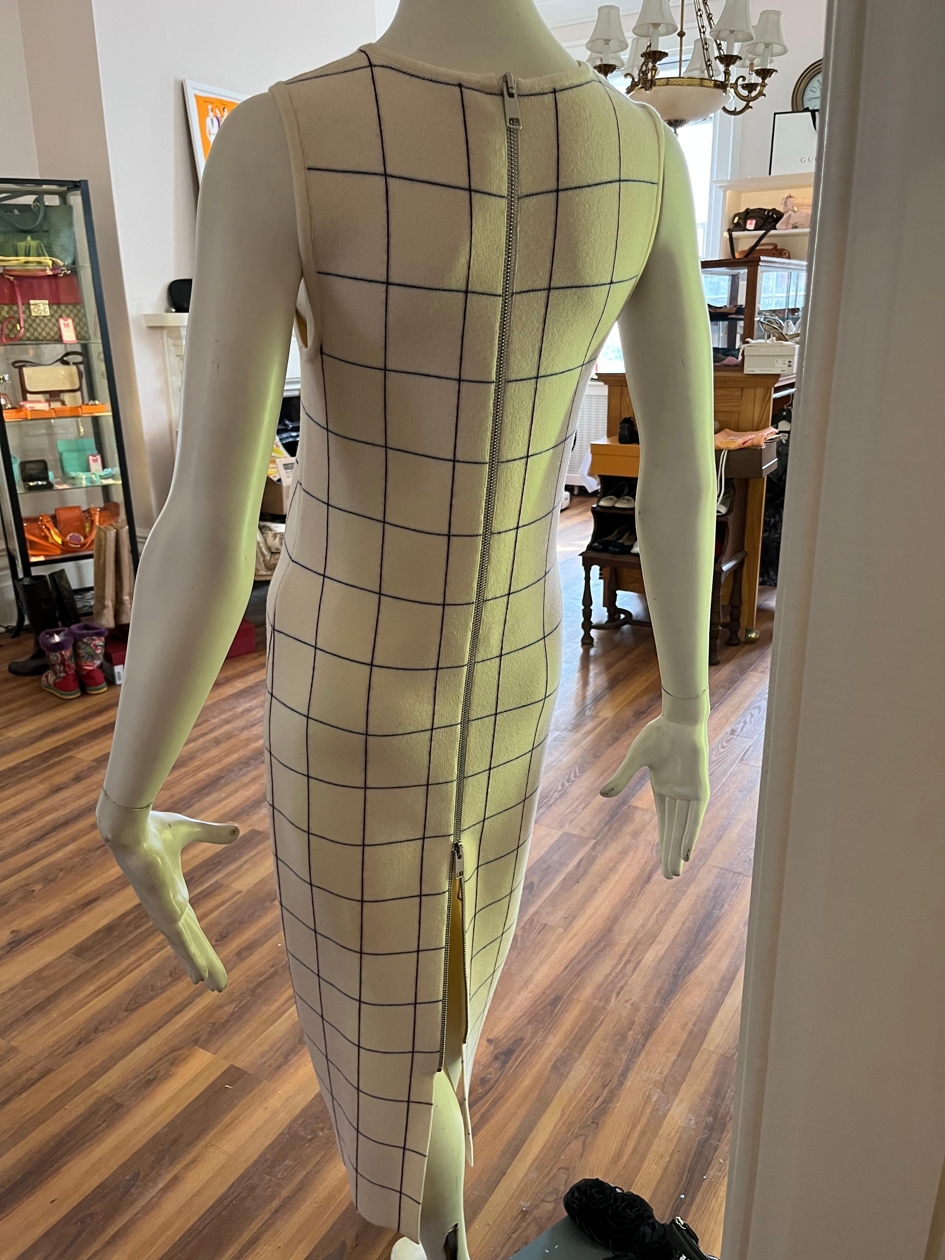 Simple and elegant the dress is suitable for many occasions. Made of 91% knit wool this dress has some stretch. Closure is by a wide exposed top to bottom zipper. Made in Italy.