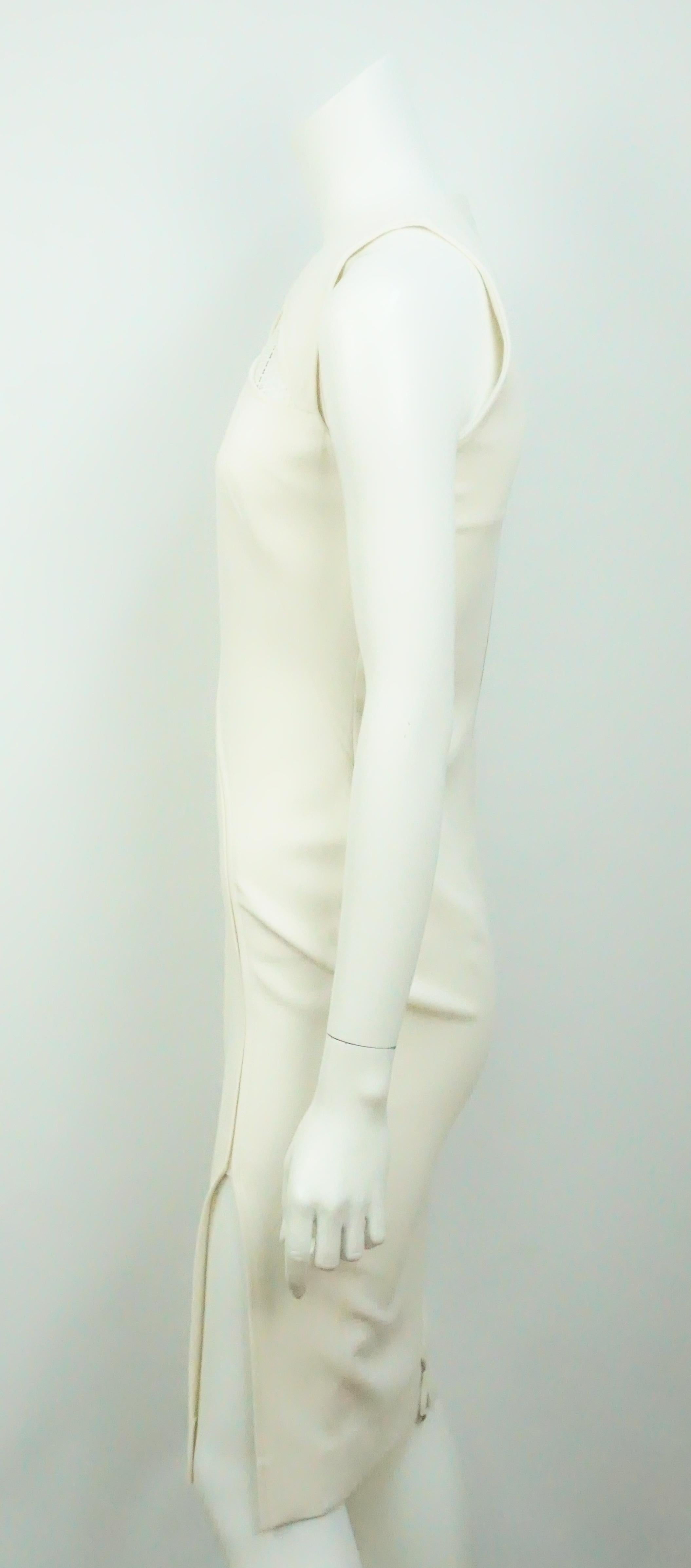 Robe ivoire Victoria Beckham-4. Cette magnifique robe sans manches est en excellent état. Il présente des découpes en dentelle et un petit slip sur le côté. La robe est un mélange de soie et de laine.
Mesures
Poitrine : 33
Taille : 28