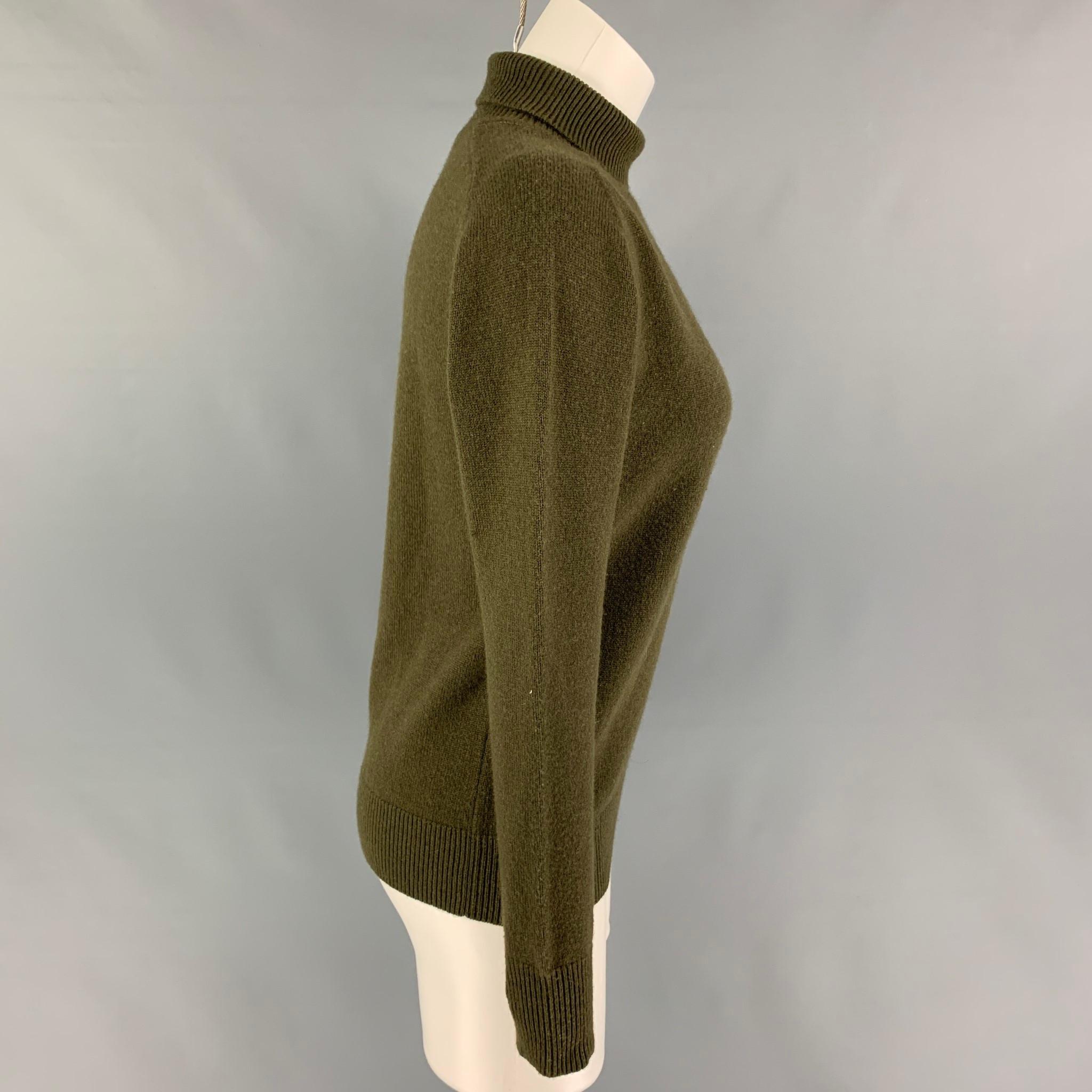 VICTORIA BECKHAM sweater comes in a olive cashmere featuring a turtleneck style and long sleeves. 

Very Good Pre-Owned Condition.
Marked: 1
Original Retail Price: $410.00

Measurements:

Shoulder: 16 in.
Bust: 36 in.
Sleeve: 22.5 in.
Length: 22.5
