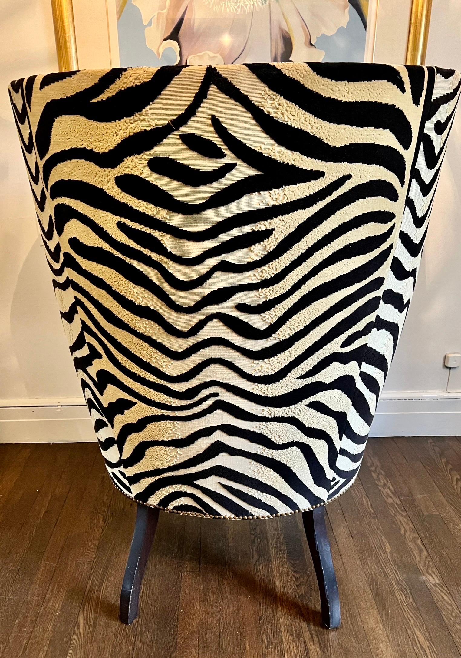 Stunning pair of Victoria Hagan Wainscott hi-back wingback chairs with softly curving arms and legs turned and fluted in a dark wood tone. Upholstered in a textured dark brown and tan zebra print chenille with loose seat cushion in down wrapped foam