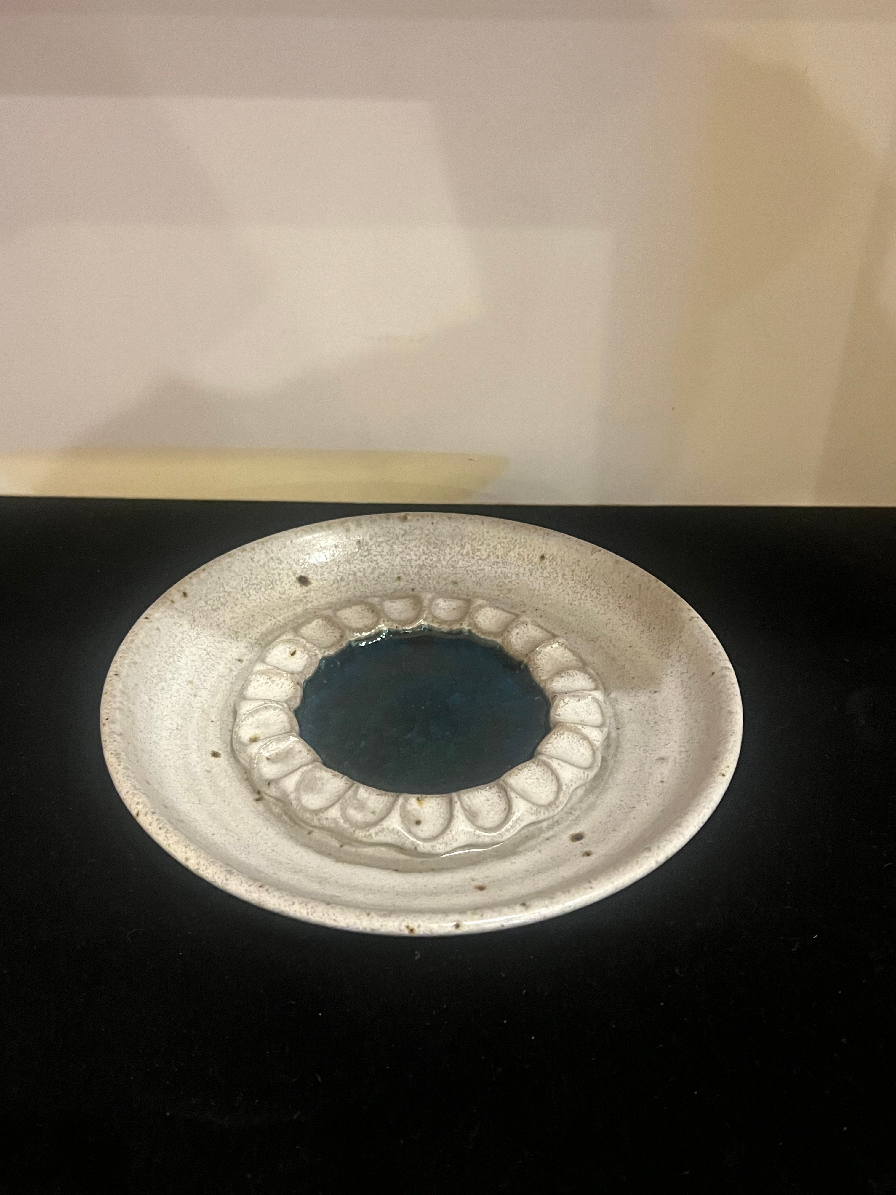 Beautiful design and color by Victoria Littlejohn, hand thrown Dish with a wonderful neutral light grey color glaze with a central blue green crystalline thick glaze surrounded by a crimped wall.

Victoria Littlejohn produced both production and