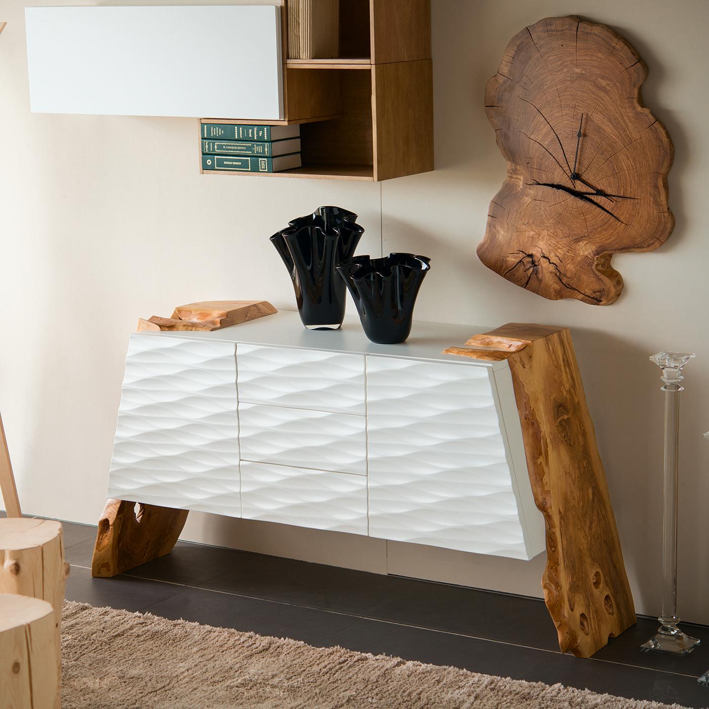 There’s an endearing elegance in the fluidity and simplicity of this sideboard's design. The minimalist geometry of the birch plywood frame with a textured, white-lacquered finish and the angled natural olive wood legs create an appealing, modern