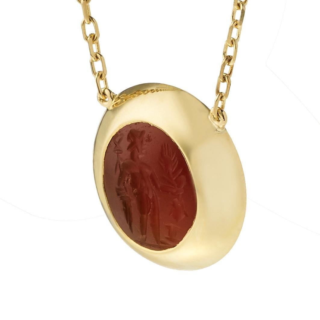 Victoria Strigini (b. 1991) 

A handcrafted contemporary 18k yellow gold necklace with a thick domed cabochon nestling an ancient Roman intaglio, in carnelian, dating from the 2nd- 3rd Century AD. The intaglio depicts Mercury, divine messenger,