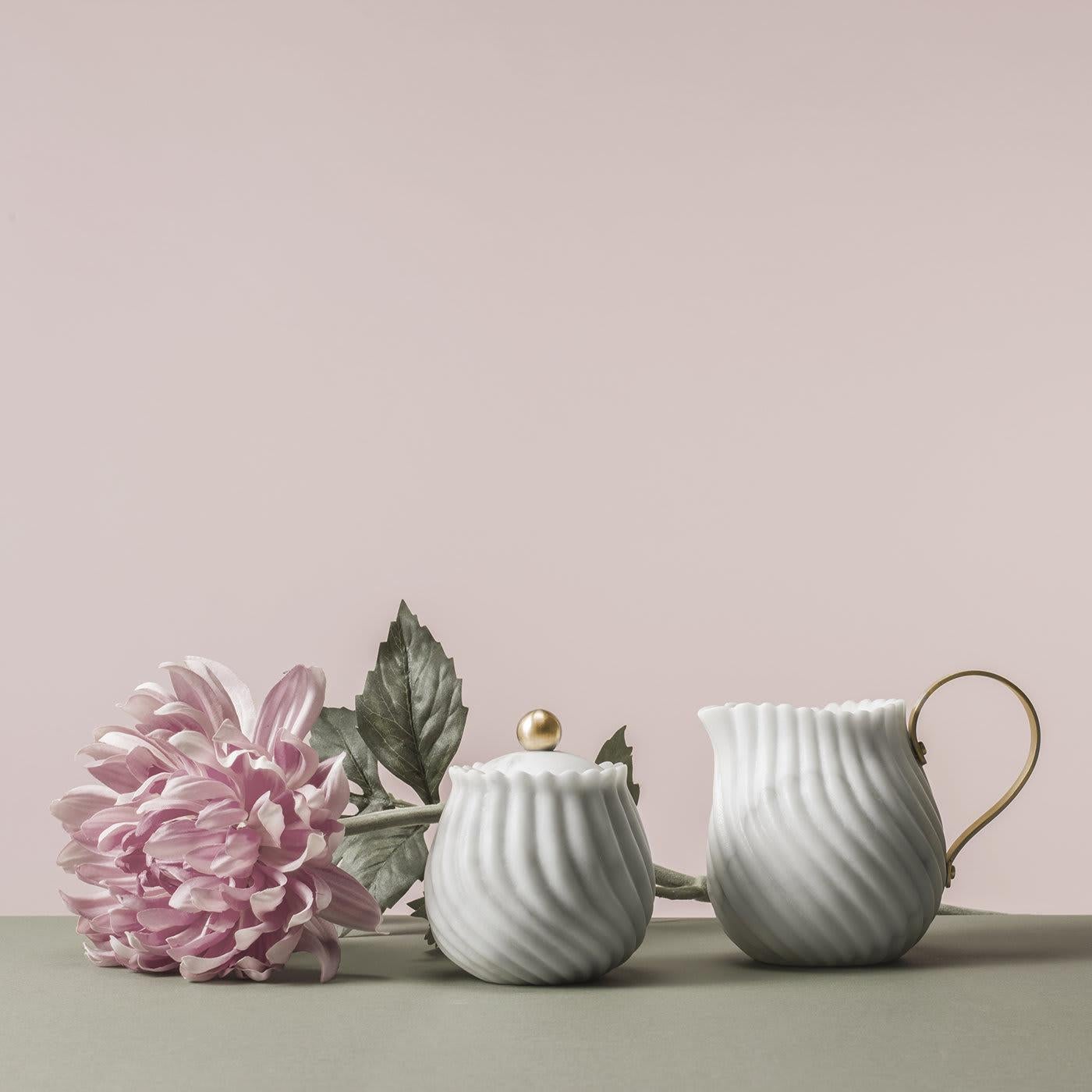 The Victoria Collection celebrates the tea ritual by merging the British afternoon tradition with a classic Italian and noble material: marble. This superb sugar bowl, part of the set, features a sinuous, hand-carved relief pattern that creates