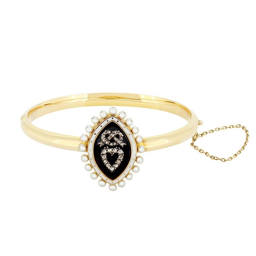 Este brazalete de luto, una auténtica pieza histórica que data de la década de 1860, está elaborado con exquisito detalle. En el centro, una pieza de esmalte negro en forma de marquesa rodeada de esmalte blanco y perlas de 2,8 mm. Dentro del esmalte
