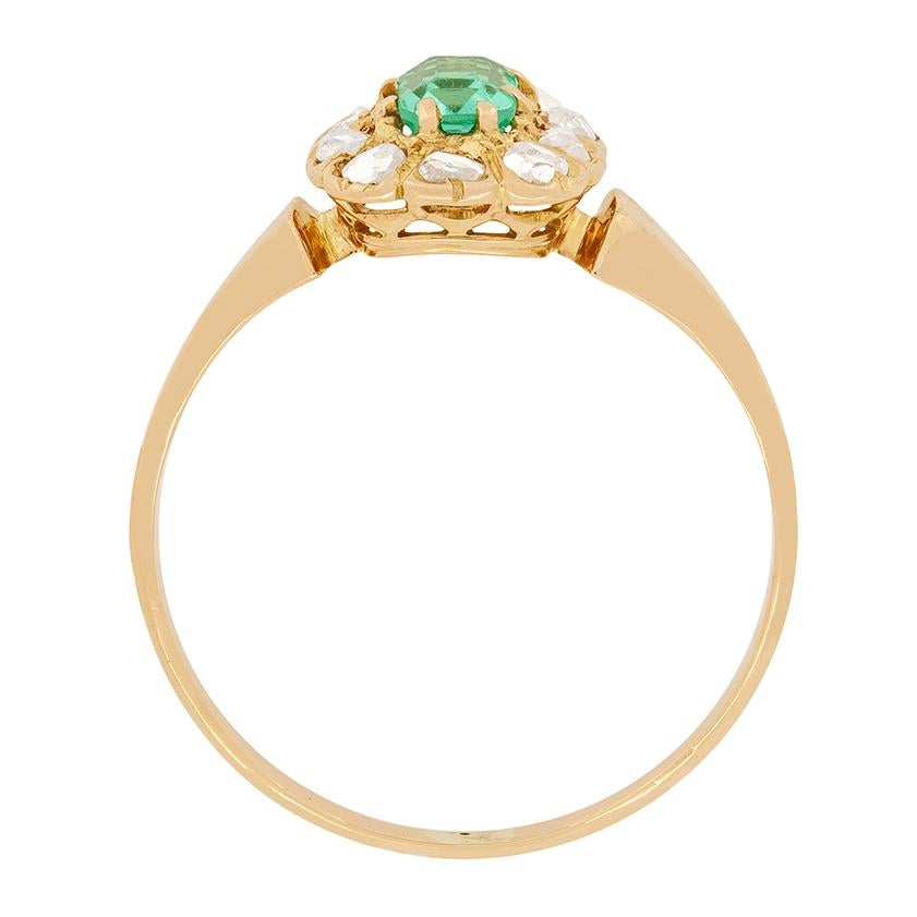 This beautiful Emerald ring dates back to the 1880s. It features a claw set 0.30 carat emerald cut emerald in its centre haloed by ten rose cut diamonds. The diamonds weigh a total of 0.20 carat. The ring itself has been hand crafted from 14 carat