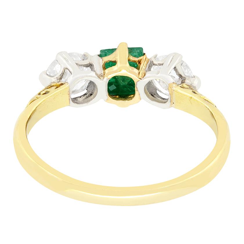 Une magnifique émeraude verte est flanquée d'une paire de diamants de taille ancienne dans cette bague victorienne. L'émeraude centrale est une pierre taillée en émeraude et pèse 0,40 carat, tandis que les diamants latéraux pèsent 0,50 carat chacun.